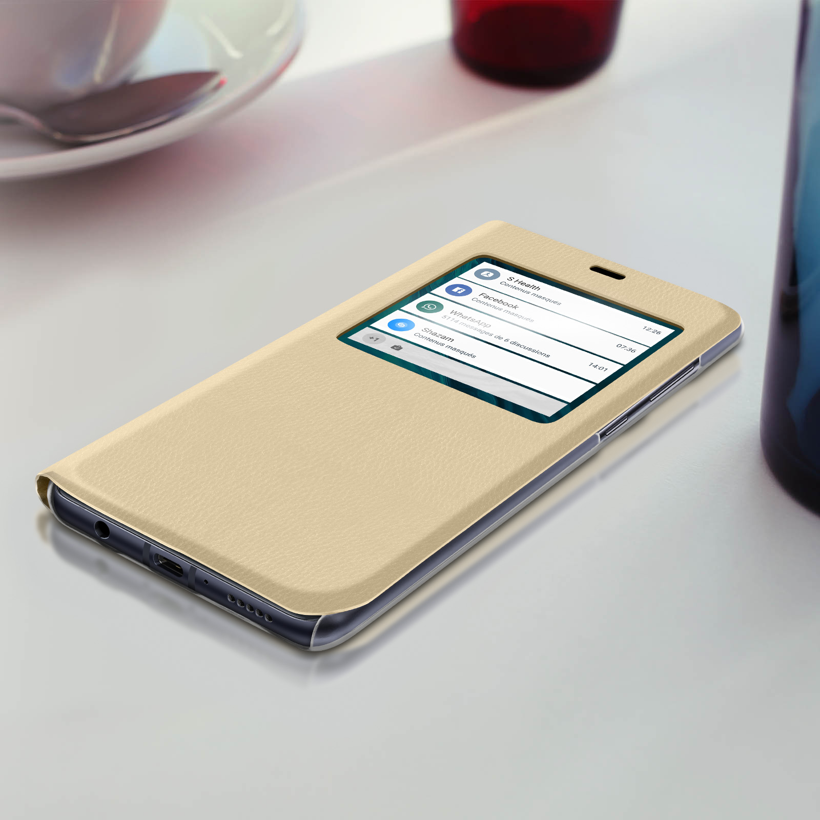 Custodia per telefono dorata con finestra che mostra le notifiche. Superficie beige, sfondo bianco.