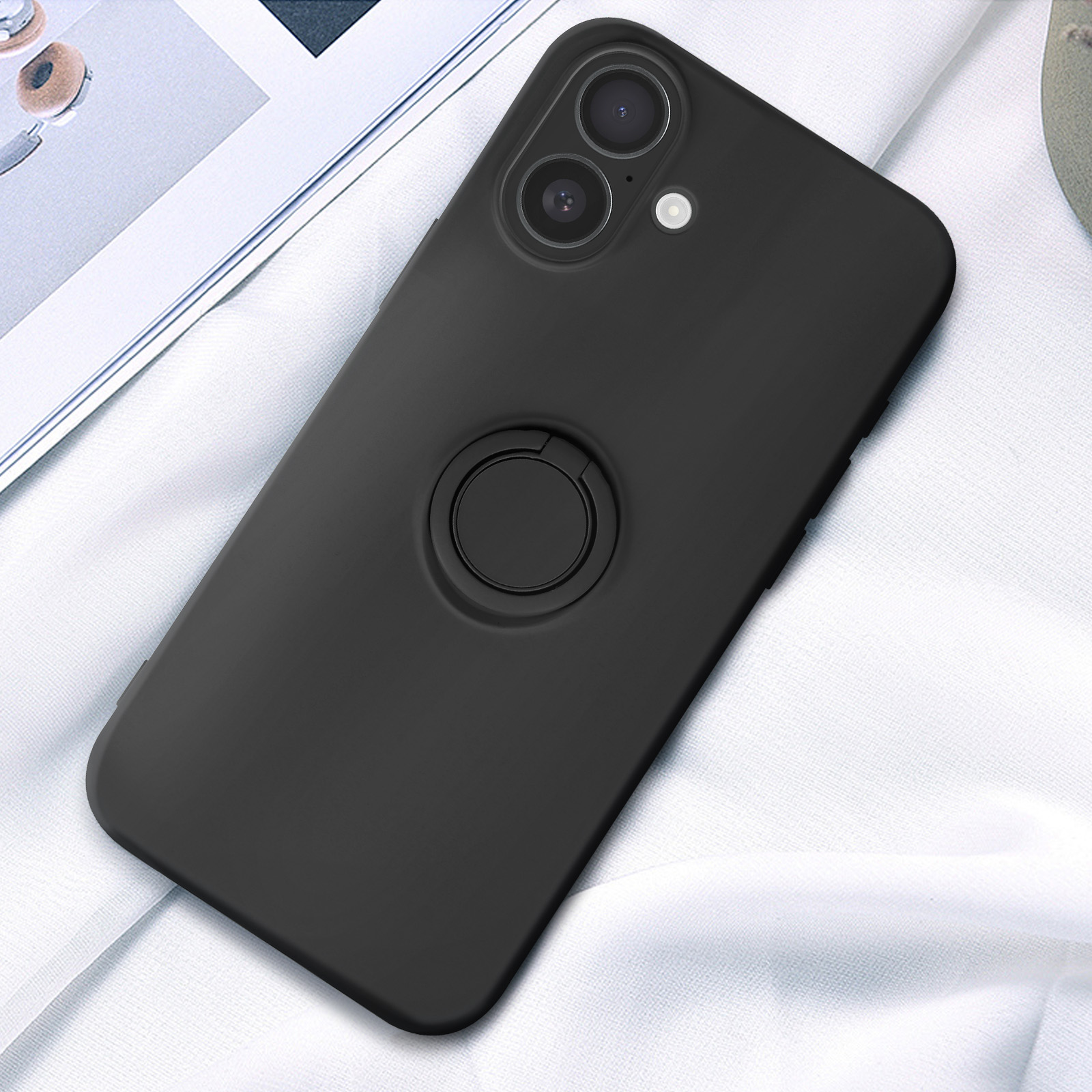Custodia nera per telefono con anello su tessuto bianco. Il telefono ha fotocamera e flash.