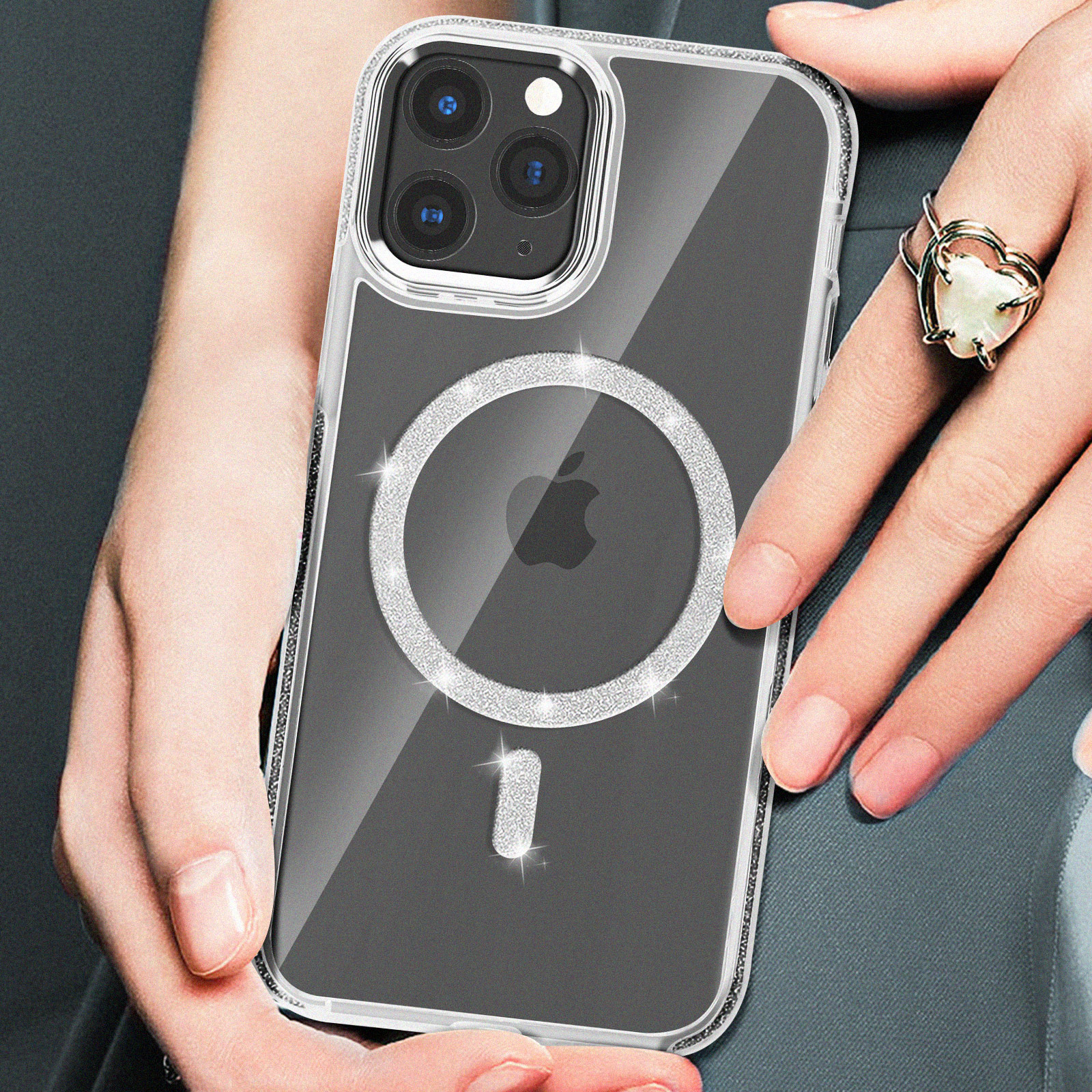 Mano che tiene telefono con custodia trasparente e anello MagSafe diamante, con anello a cuore.