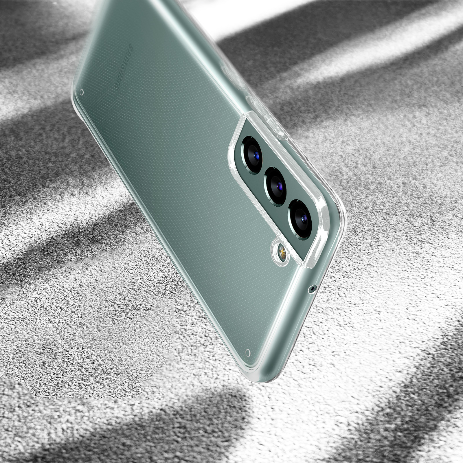 Custodia per telefono con obiettivi della fotocamera visibili, posizionata su una superficie strutturata. La custodia è trasparente.