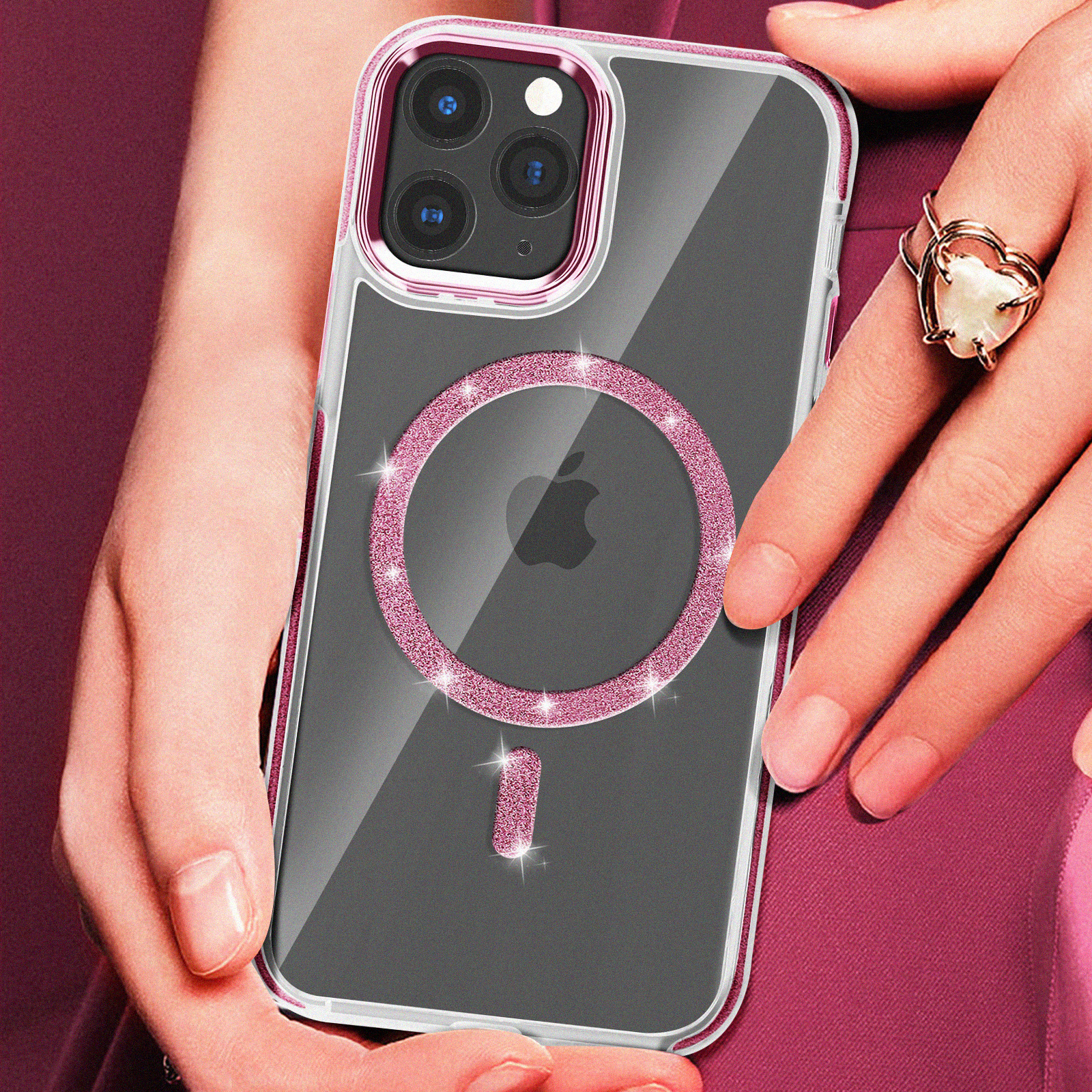Una persona tiene in mano un telefono con una custodia rosa scintillante. Il telefono ha un rialzo per la fotocamera e un anello con una gemma a forma di cuore.
