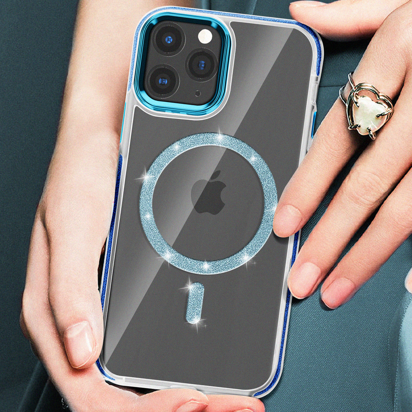 Mano che tiene una custodia con un anello glitterato blu. Logo Apple sul telefono. Cornice blu.