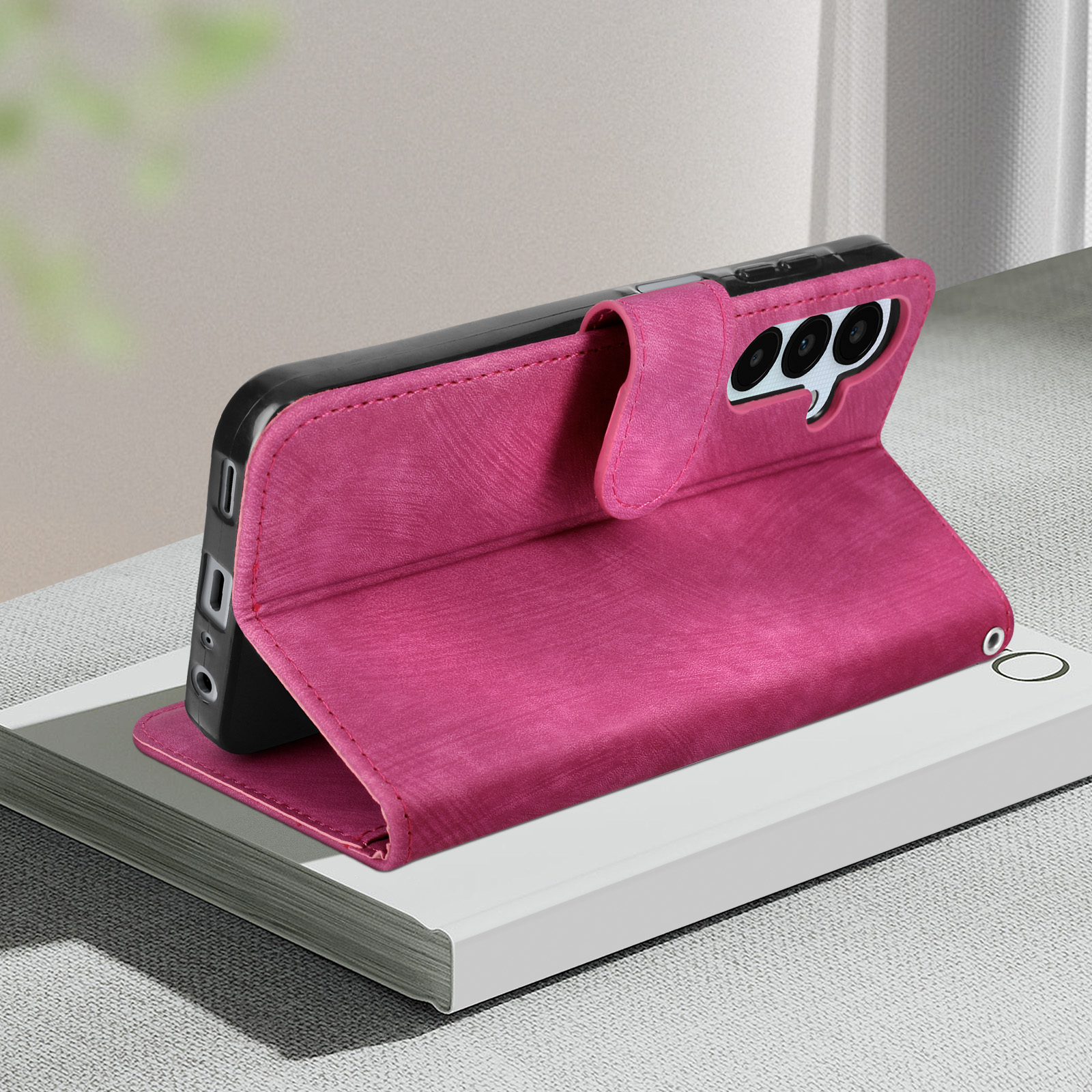 Custodia rosa in modalità supporto. Il telefono è nella custodia. La custodia è su una superficie bianca.