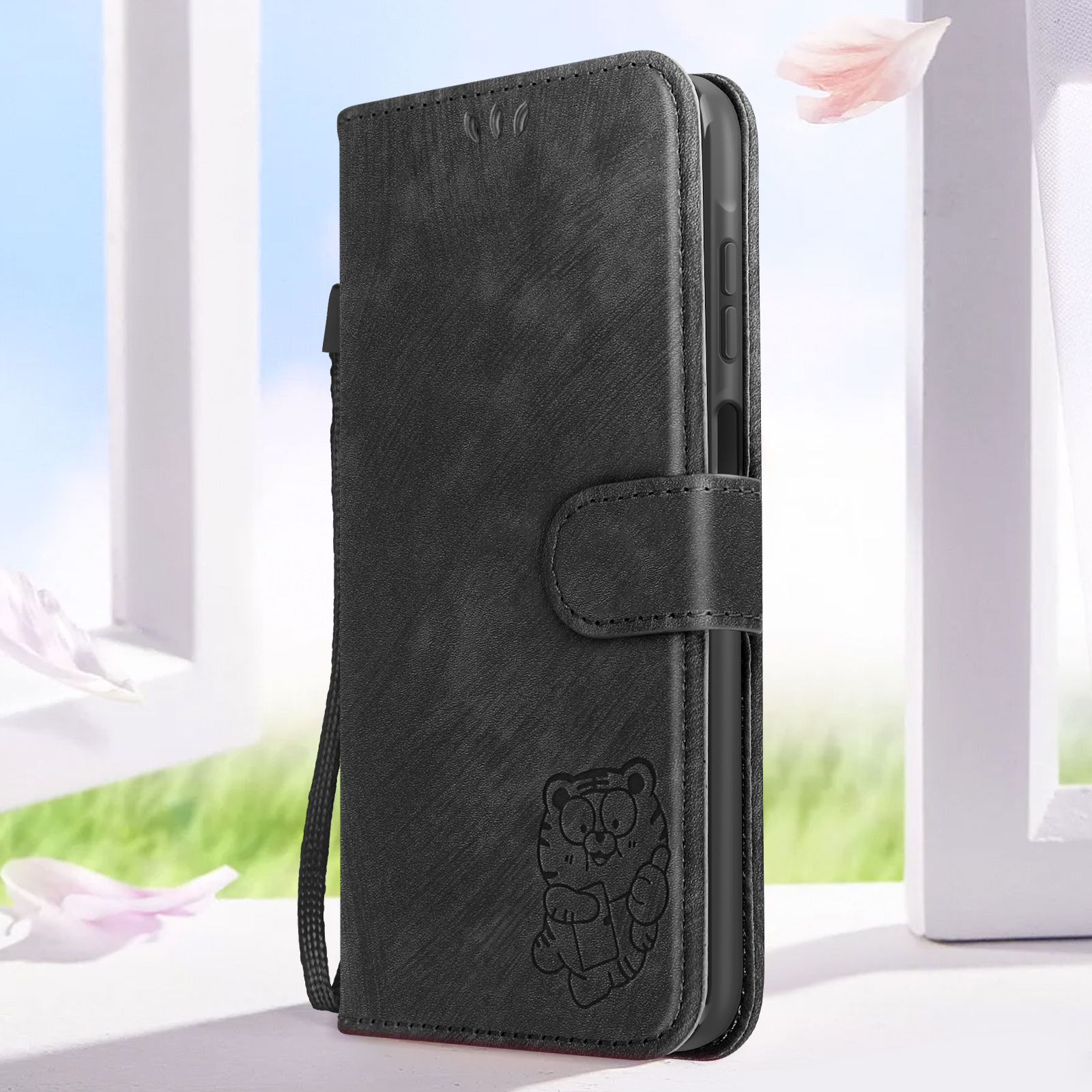 Custodia nera con disegno di tigre. Aperta per mostrare un telefono all'interno. Sfondo di petali rosa.