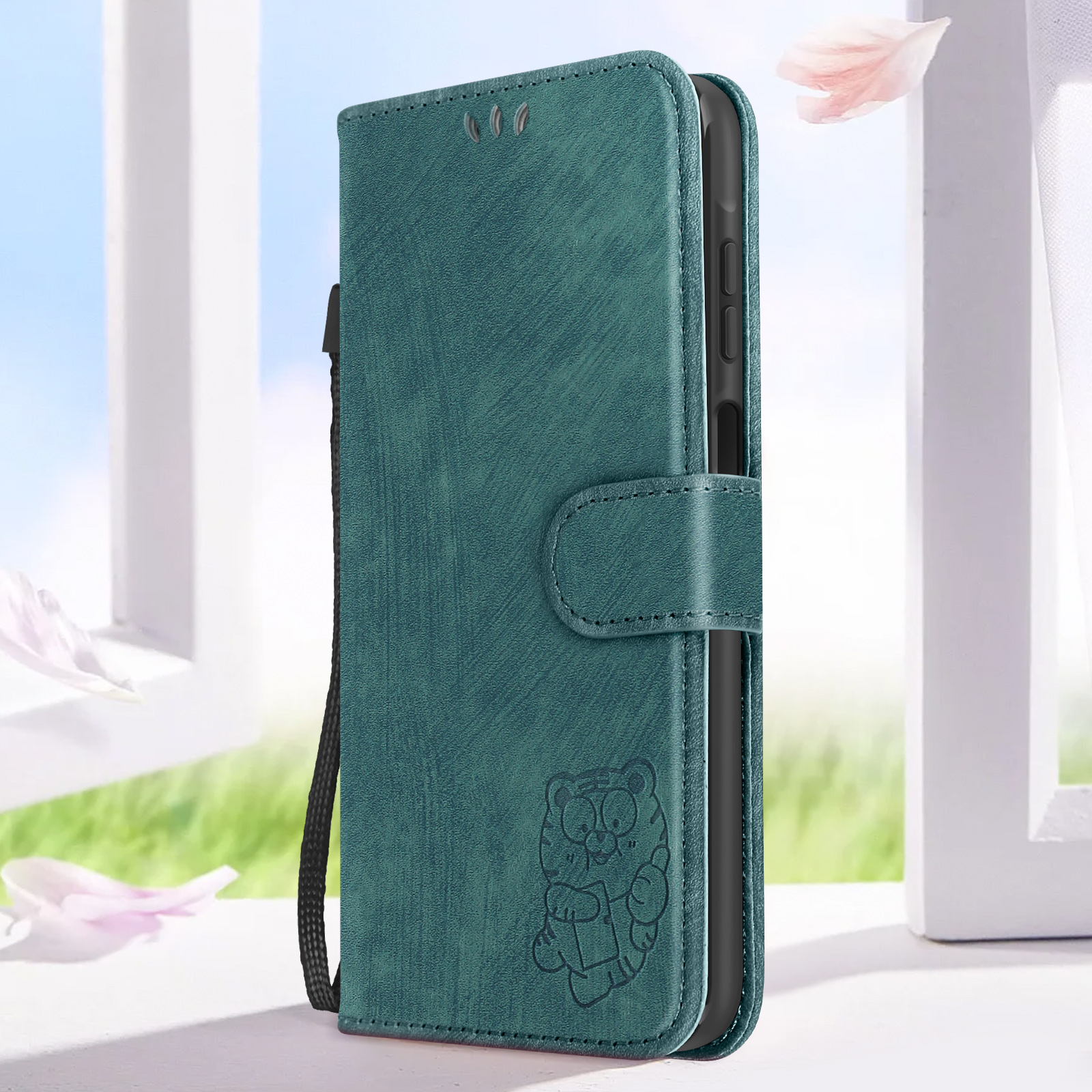 Custodia per telefono verde acqua, aperta, che mostra il telefono. Un tigre dei cartoni animati è sulla custodia. Sfondo di petali.