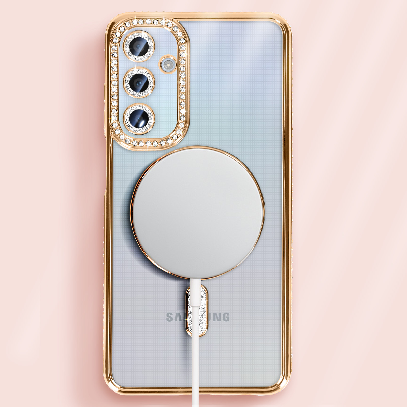 Custodia dorata con strass, MagSafe e cavo di ricarica su sfondo rosa.