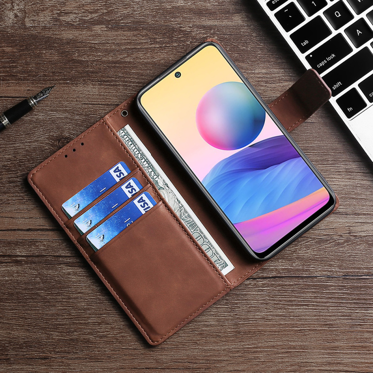 Telefono su un tavolo di legno con carte, soldi e una penna.