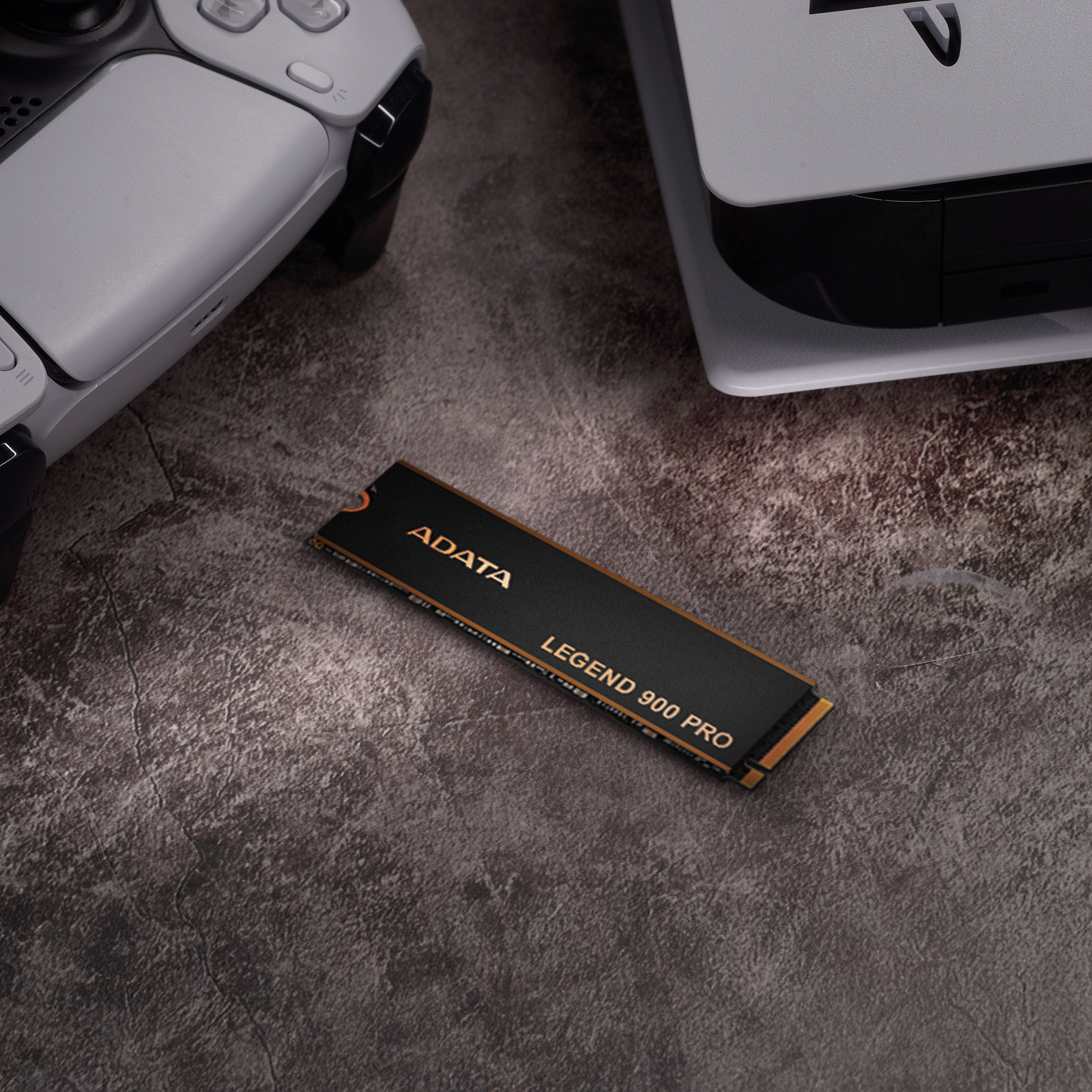 Disque SSD, noir et or, à côté d'une PS5 et d'une manette sur une surface grise.