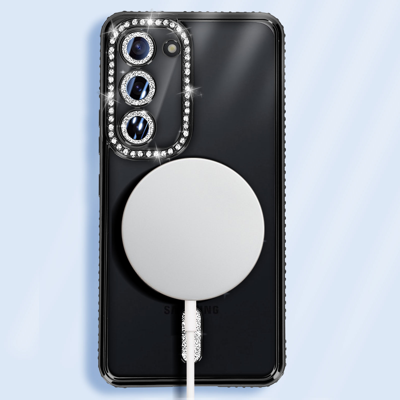 Telefono nero con un cerchio bianco e un cavo di ricarica. La custodia ha strass attorno alla fotocamera.