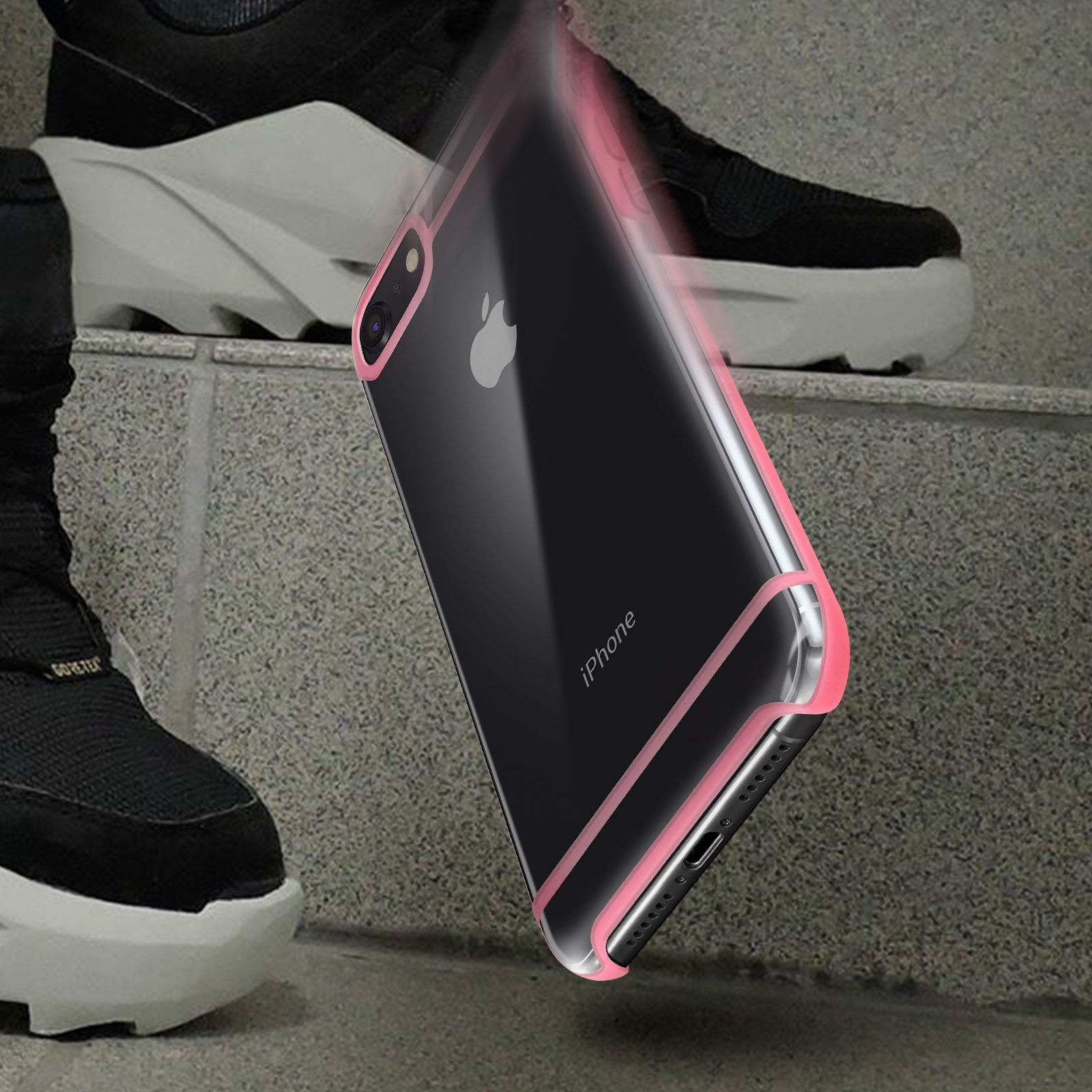 iPhone in custodia con bordi rosa, vicino ai piedi di una persona. Scarpe nere e scale visibili.