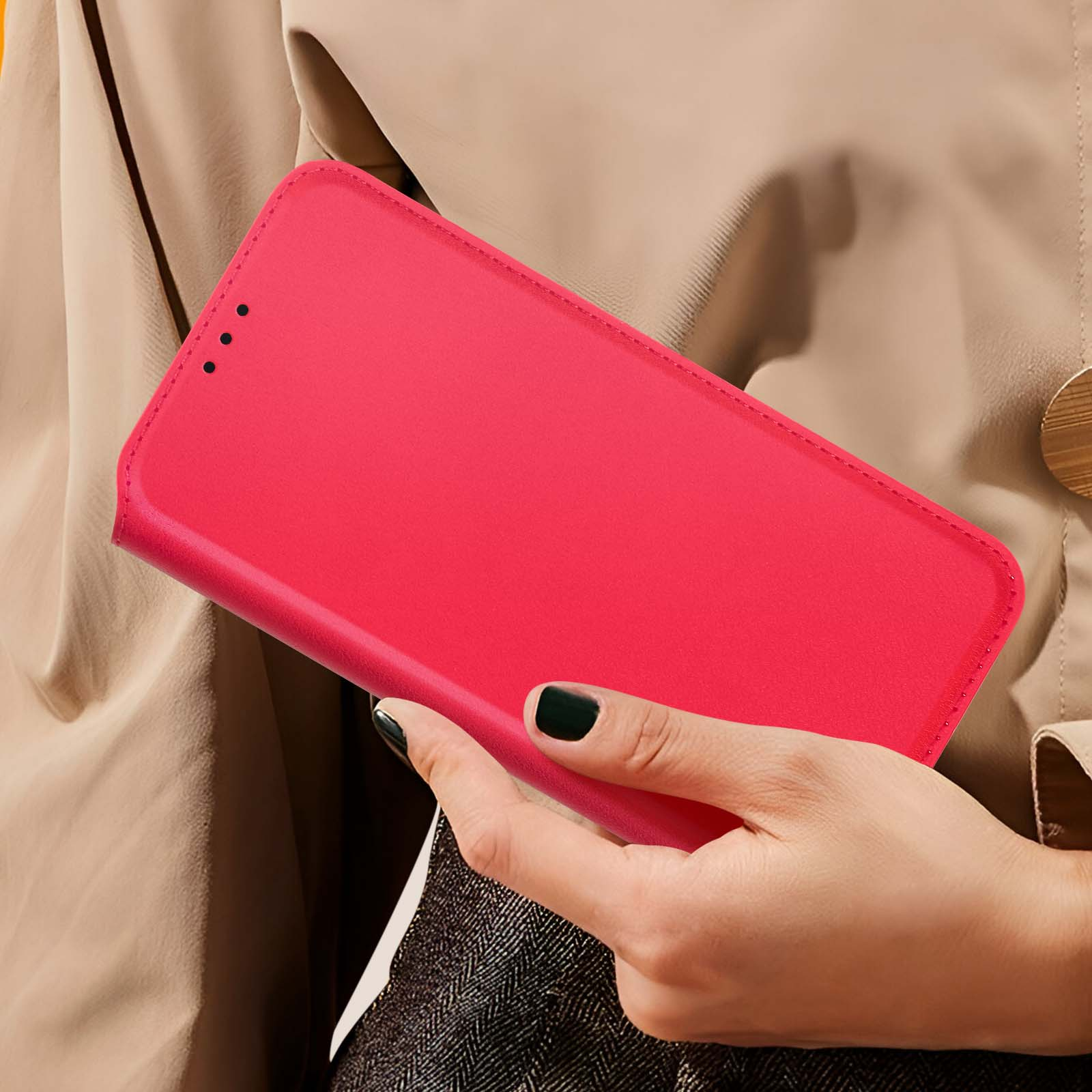 Una mano che tiene una custodia rossa per telefono contro una giacca beige.