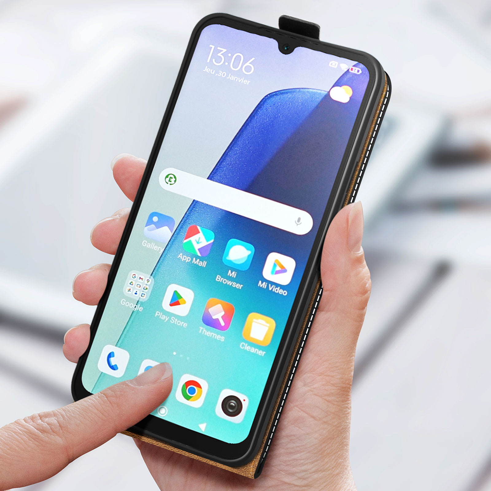 Telefono in una custodia in pelle marrone. Un dito tocca lo schermo. Le icone delle app sono visibili.