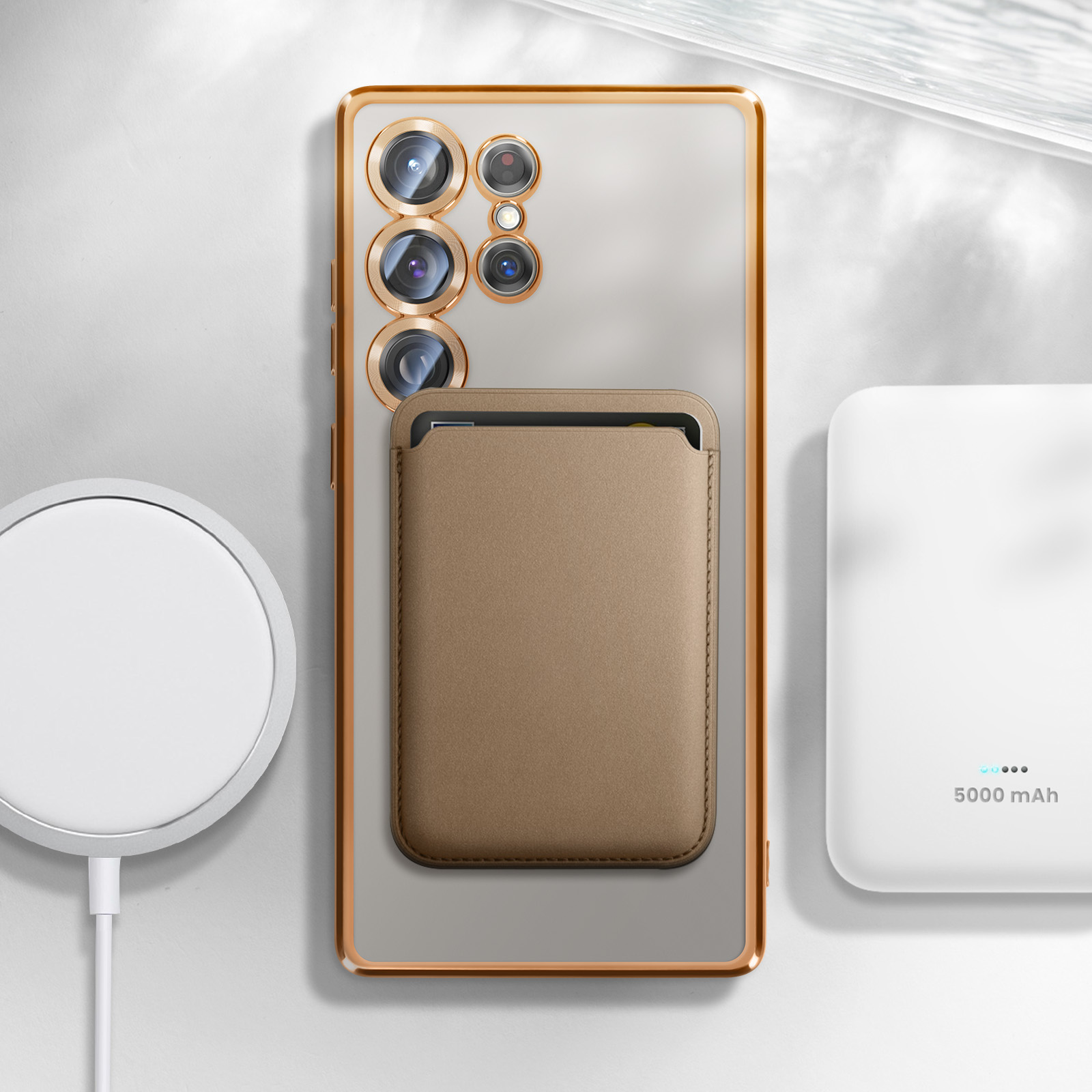 Un telefono con un porta carte collegato, accanto a un tappetino di ricarica e a un power bank. Sfondo bianco.