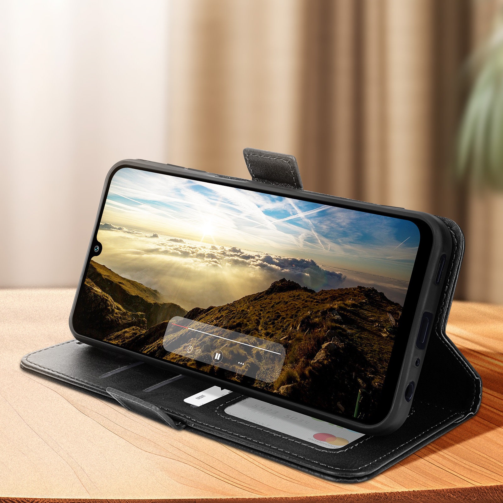 Schwarze Handyhülle offen, mit Telefon darin, das ein Landschaftsvideo auf dem Bildschirm zeigt.