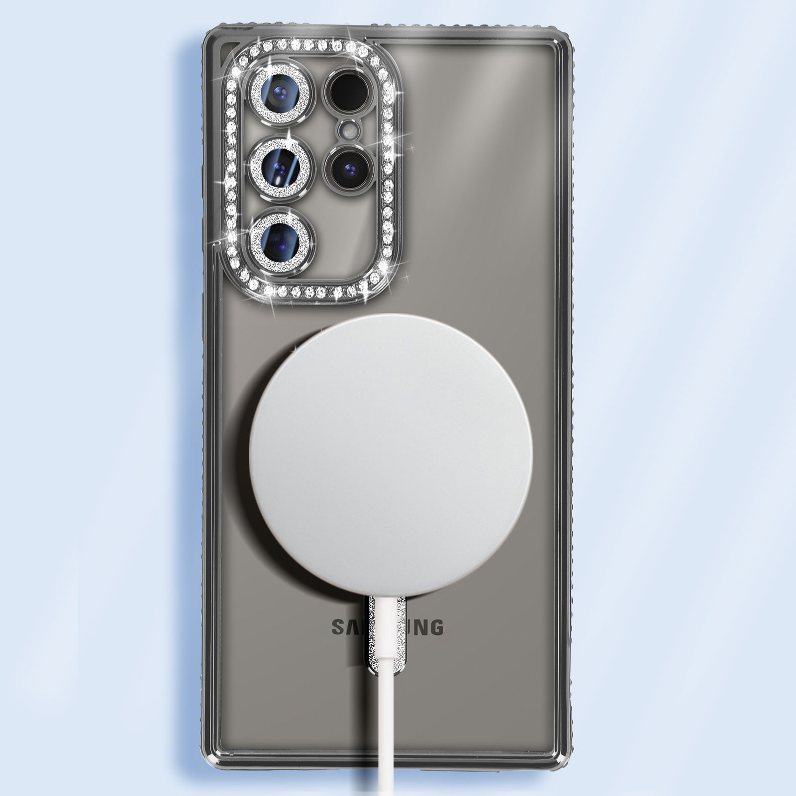 Telefono con custodia di diamanti argentati e un pad di ricarica bianco.