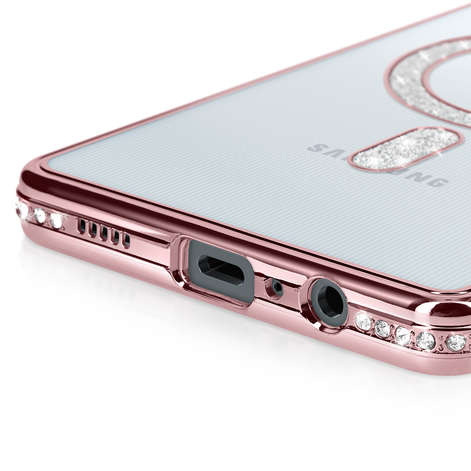 Primo piano della custodia del telefono con bordi oro rosa e retro trasparente. Strass visibili.