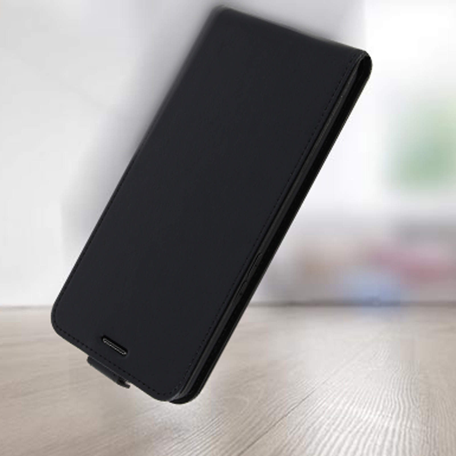 Custodia per telefono chiusa, su una superficie di legno. La custodia è nera.
