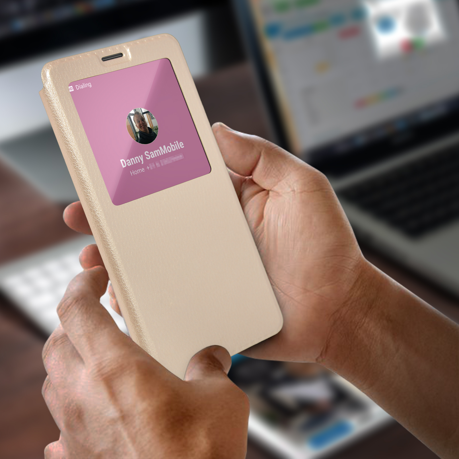Una persona tiene un telefono beige con schermo rosa che mostra un contatto e una foto.