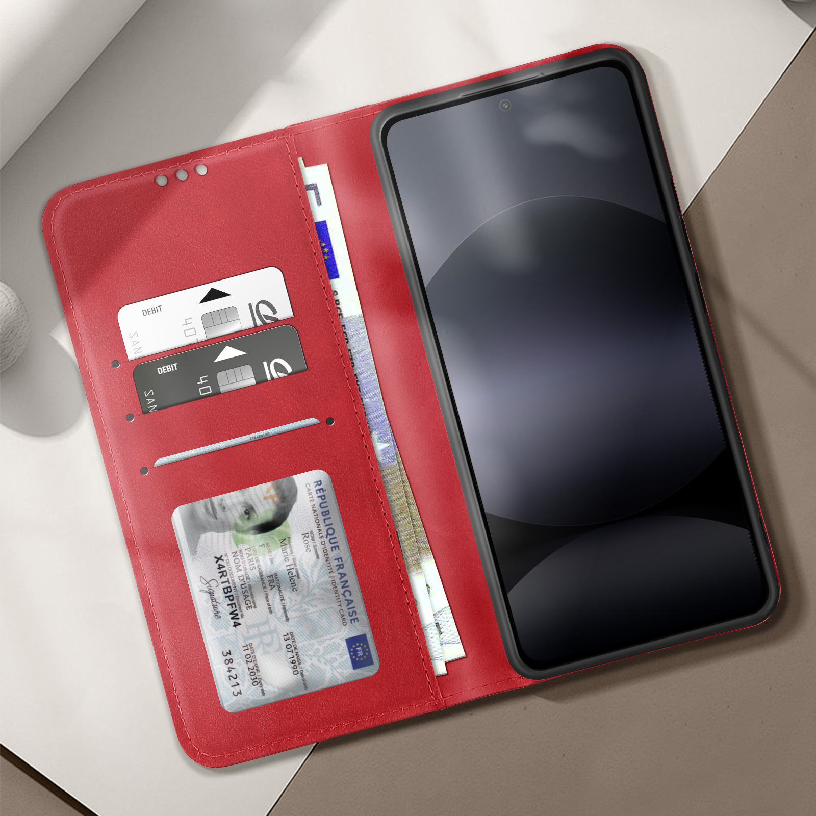 Custodia rossa aperta, telefono dentro. Carte di credito e ID visibili. Sfondo chiaro.