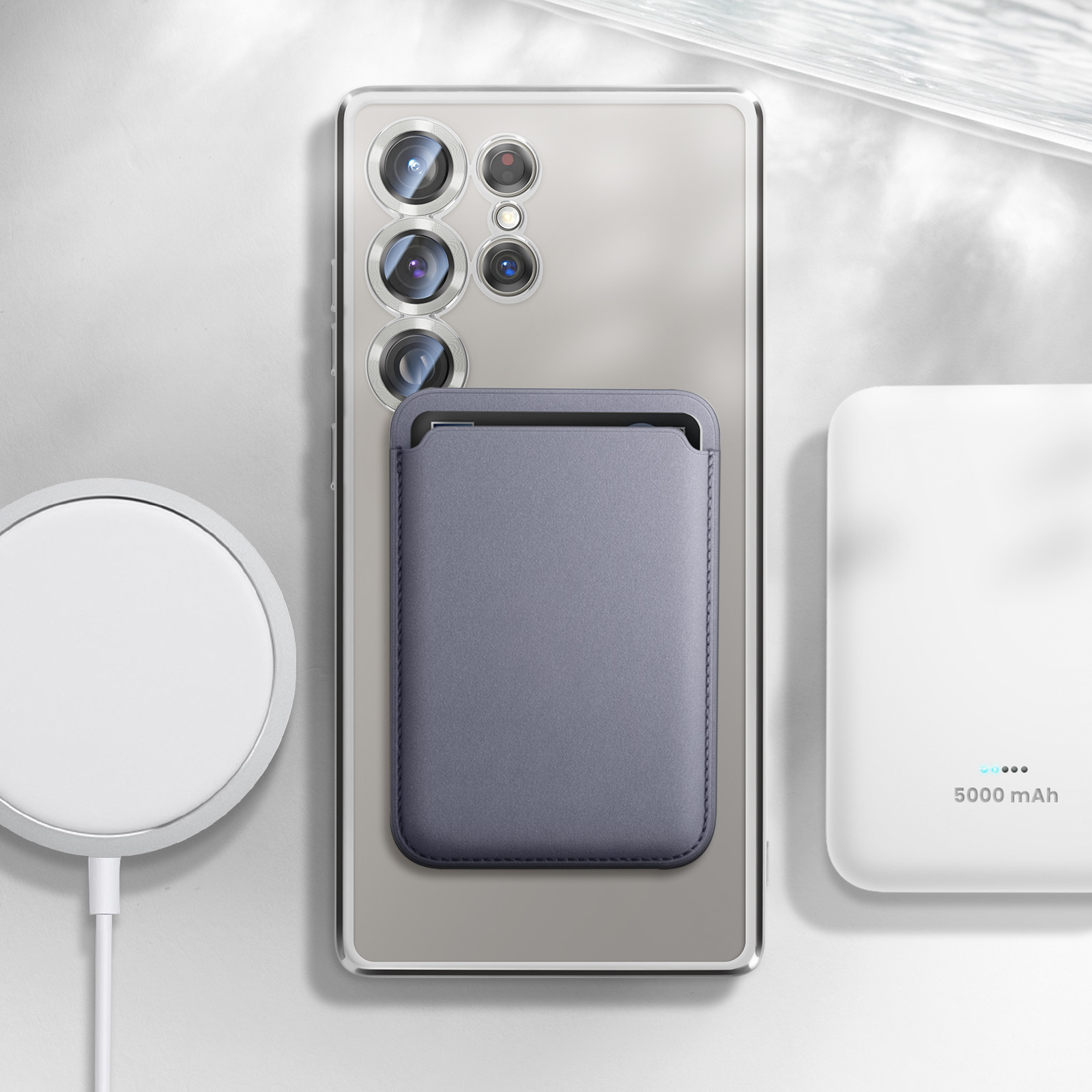Un telefono con un accessorio portafoglio e un caricabatterie accanto a un power bank. L'impostazione è su una superficie bianca.