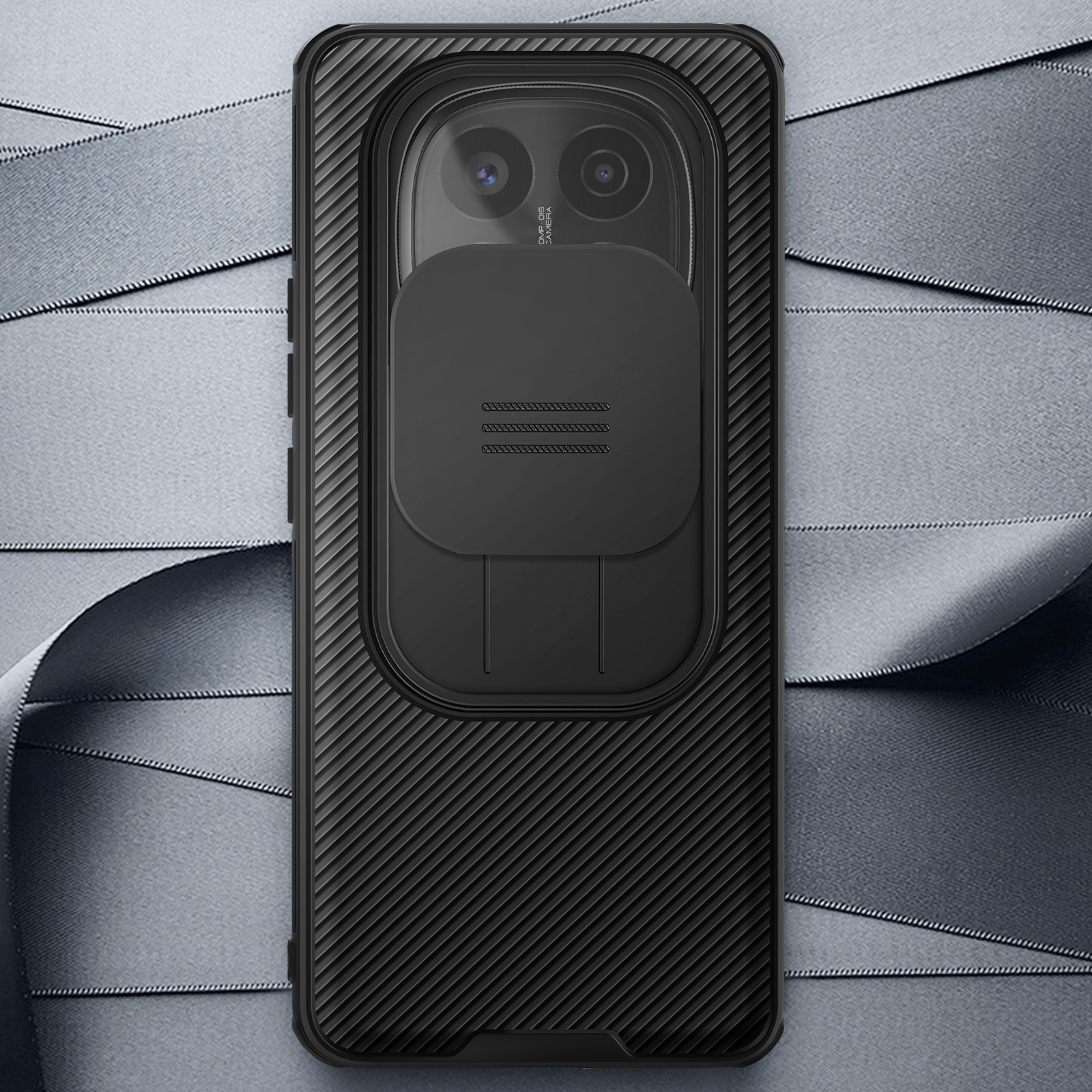 Custodia per telefono nera con motivo strutturato e copertura per fotocamera, su sfondo di nastro grigio.