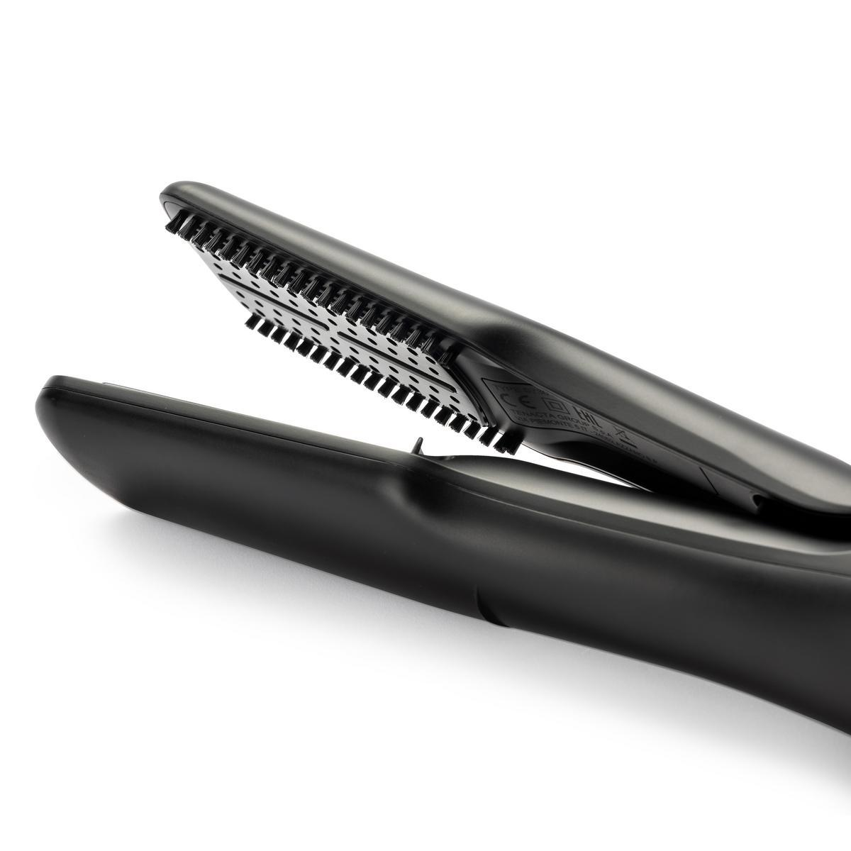Czarna prostownica do włosów, otwarta, z widocznymi płytkami grzewczymi i nasadką w kształcie grzebienia, ujęcie pod kątem.