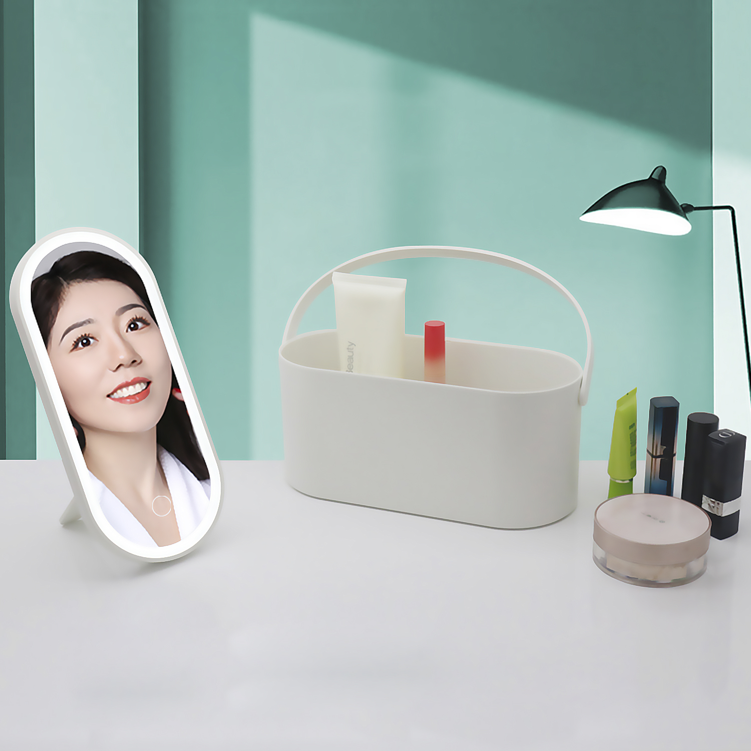 Una mujer se mira en un espejo iluminado. Productos de maquillaje y una cesta blanca están sobre una mesa. Una lámpara está a la derecha.