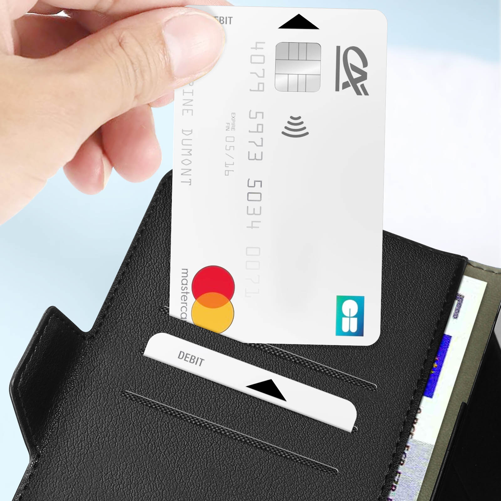 Una mano inserisce una carta di credito in un portafoglio, con il testo 'DEBIT' visibile.