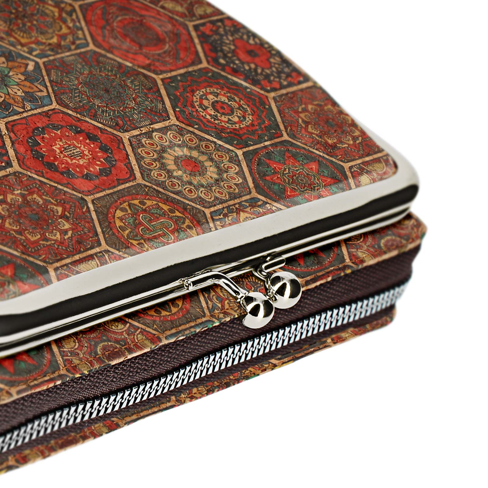 Nahaufnahme einer gemusterten Clutch mit silbernem Verschluss und Reißverschluss. Weißer Hintergrund.
