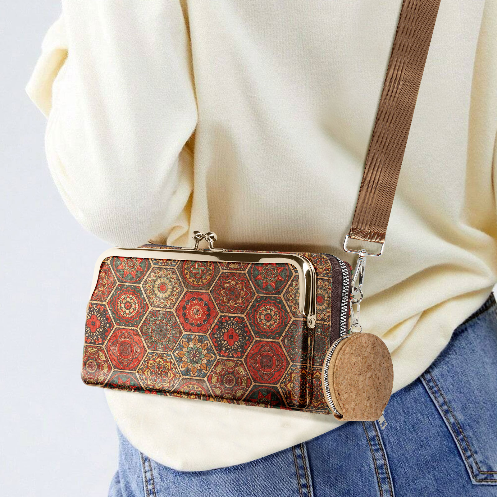 Gemusterte Clutch-Geldbörse mit braunem Riemen an einer Frau.