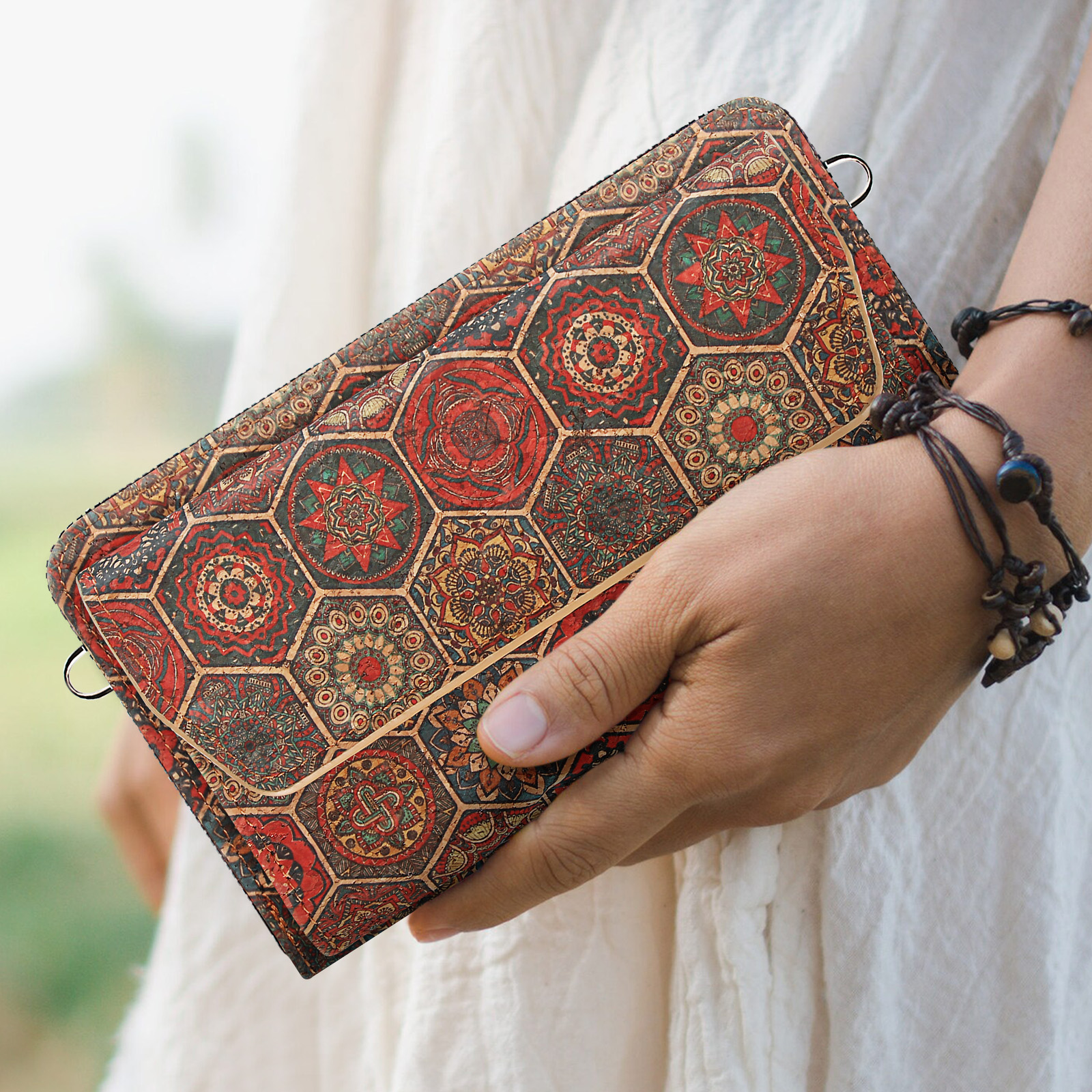 Person hält eine Korkbrieftasche mit gemustertem Design.