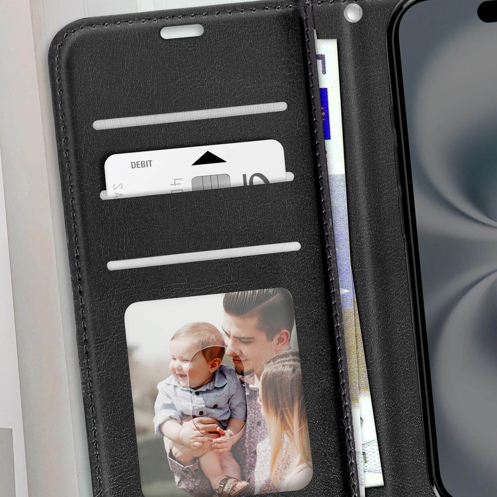 Un portafoglio nero per telefono aperto, che mostra una carta di debito, denaro e una foto di un uomo e un bambino.