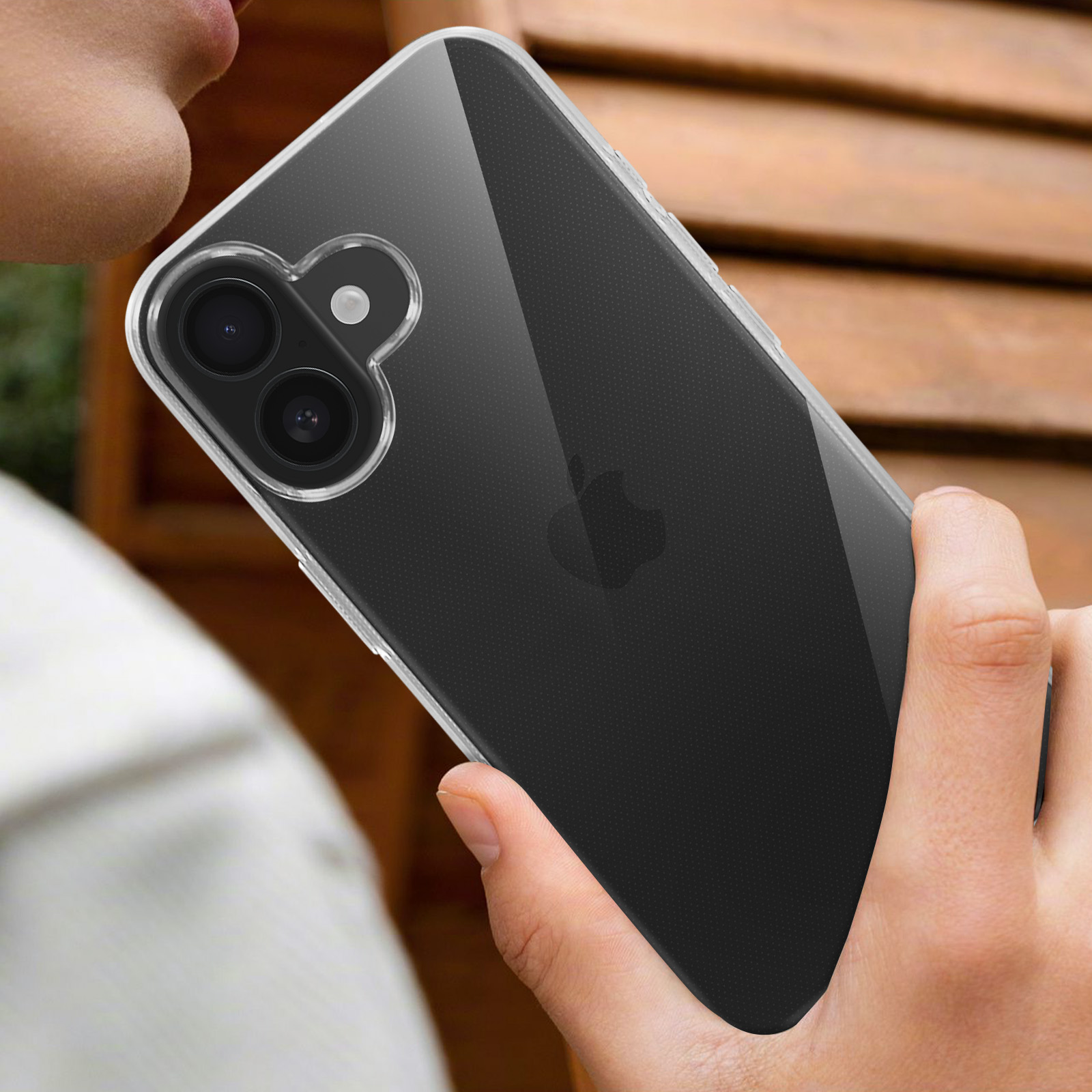 Una persona tiene una custodia trasparente, mostrando il retro di un telefono nero.