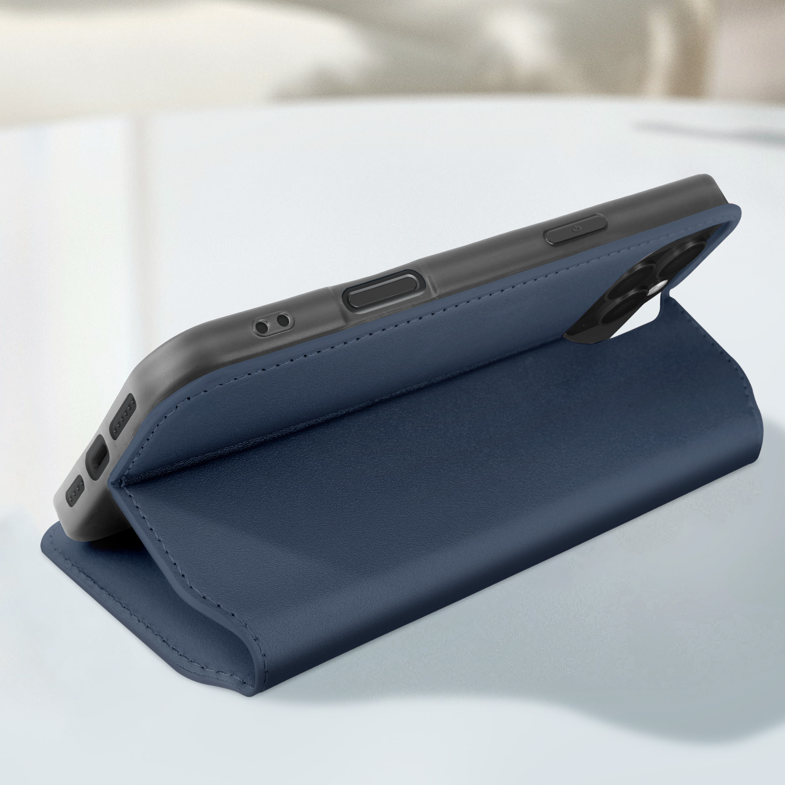 Custodia blu per telefono, parzialmente aperta. Il telefono è nero con protuberanza della fotocamera. Superficie bianca.