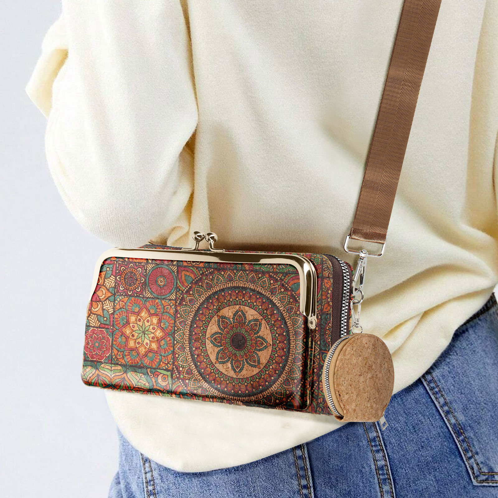 Person mit weißem Pullover und Geldbörse mit Blumenmuster und kleiner runder Geldbörse.
