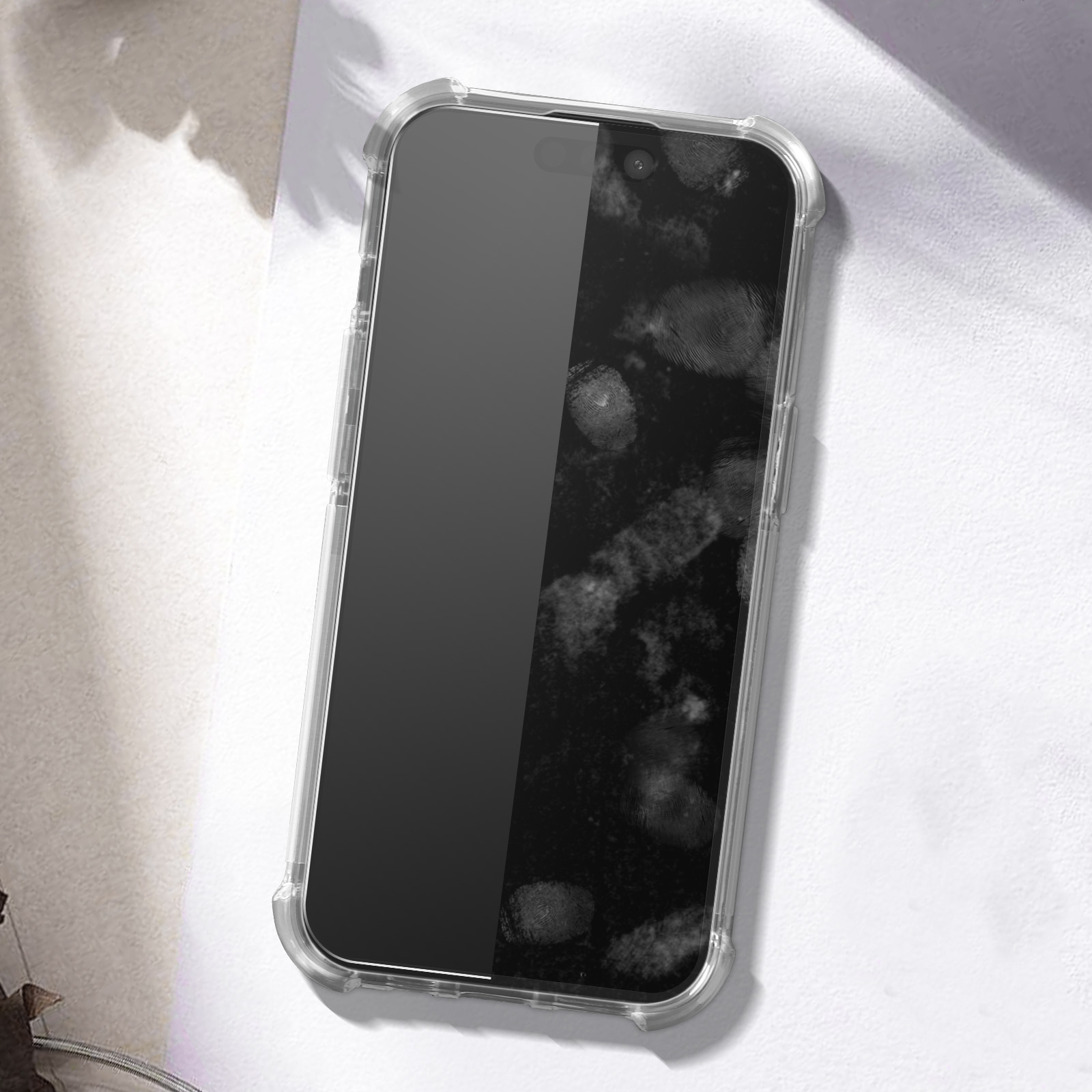 Un telefono in una custodia trasparente con impronte digitali sullo schermo. Lo sfondo è una superficie bianca.