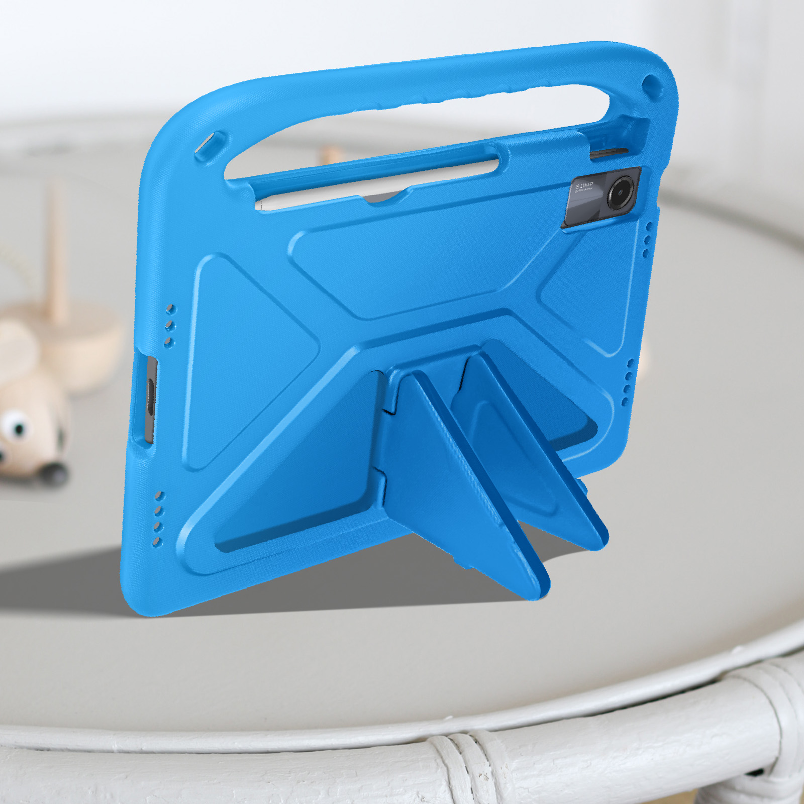 Custodia per tablet blu con maniglia e supporto. Il supporto sostiene la custodia. In un ambiente interno. Superficie in legno.