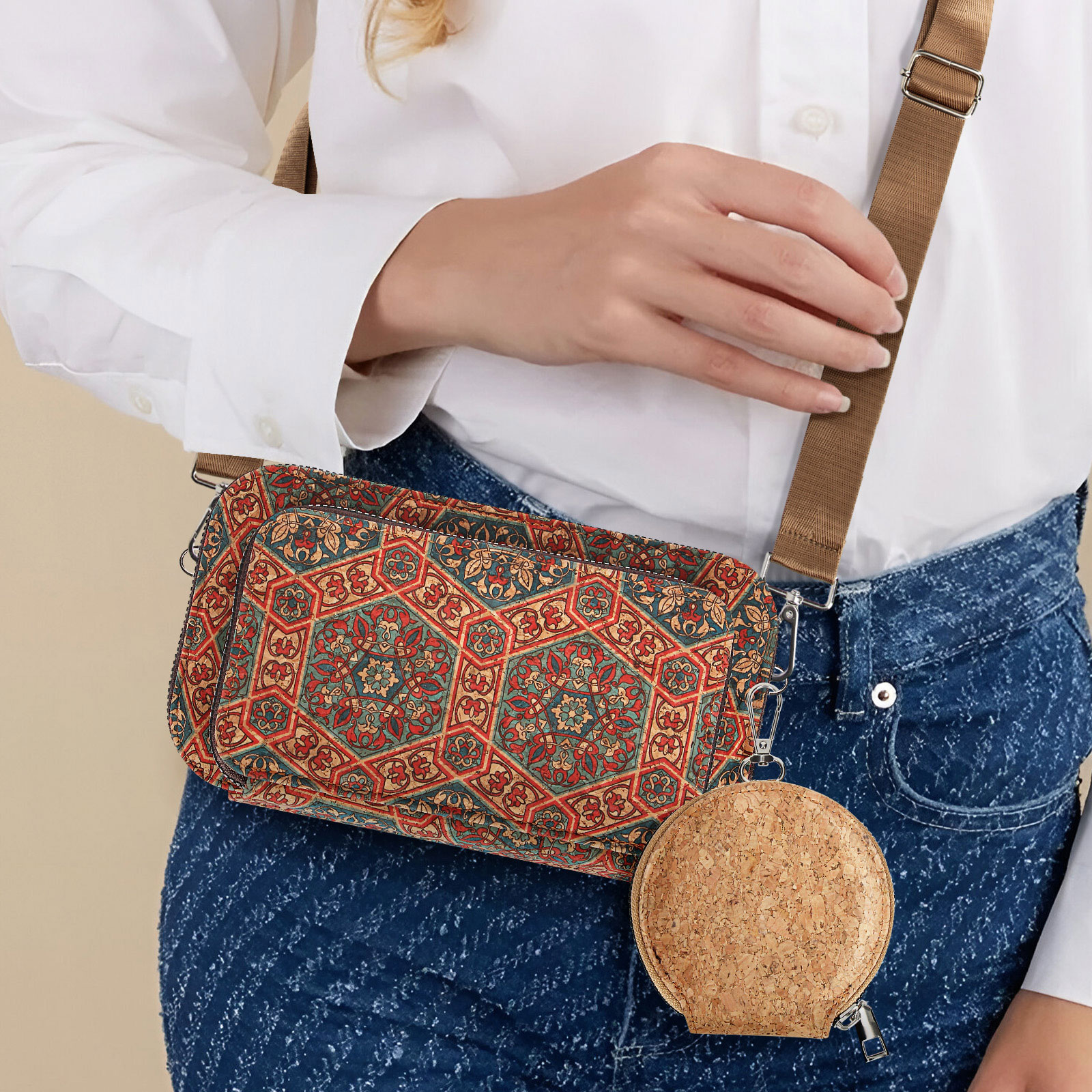 Eine Frau mit einer gemusterten Tasche und einer runden Korkbörse, die steht. Sie trägt Jeans und ein weißes Hemd.