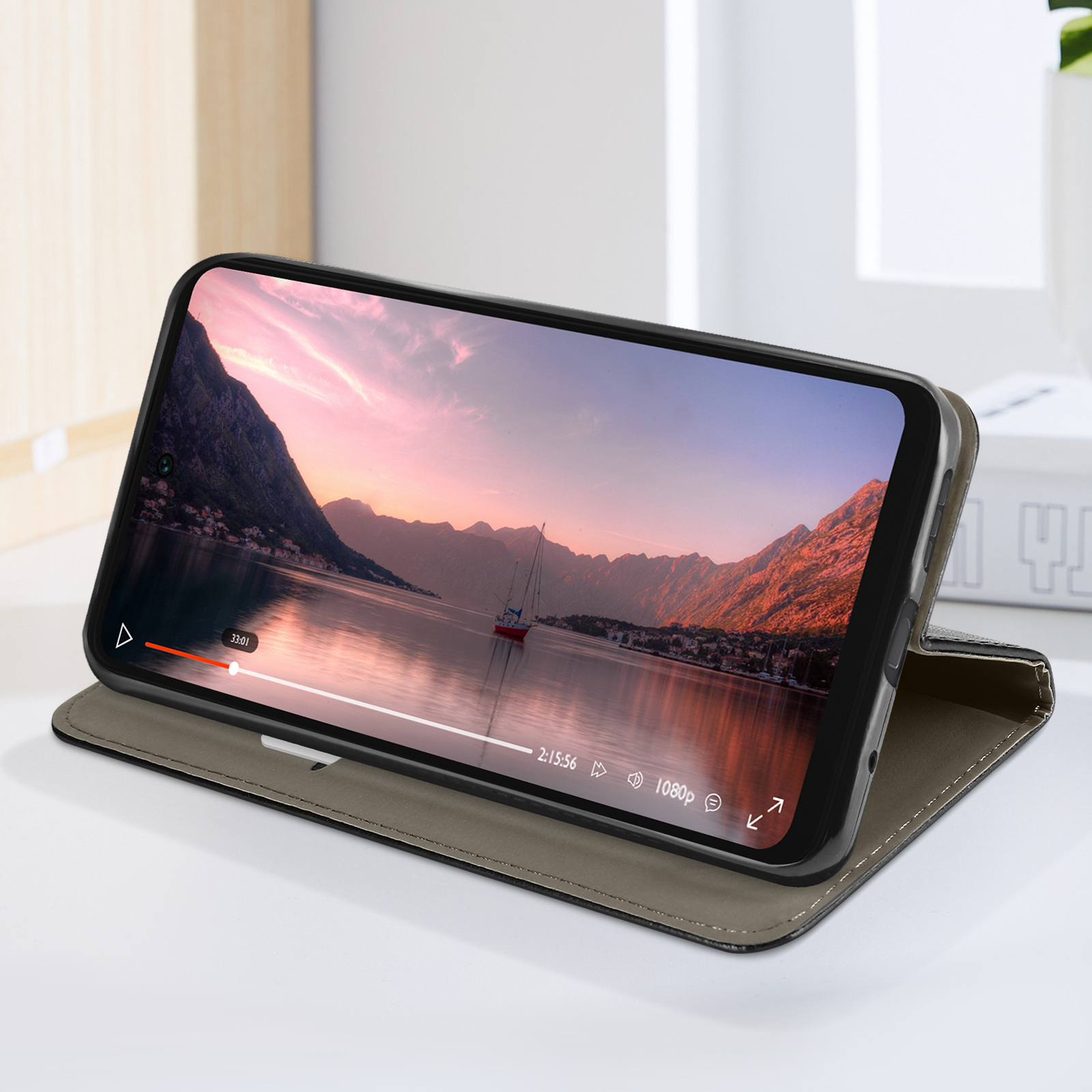 Telefon in einer Hülle, zeigt ein Video eines Boots auf einem See. Hülle ist offen.