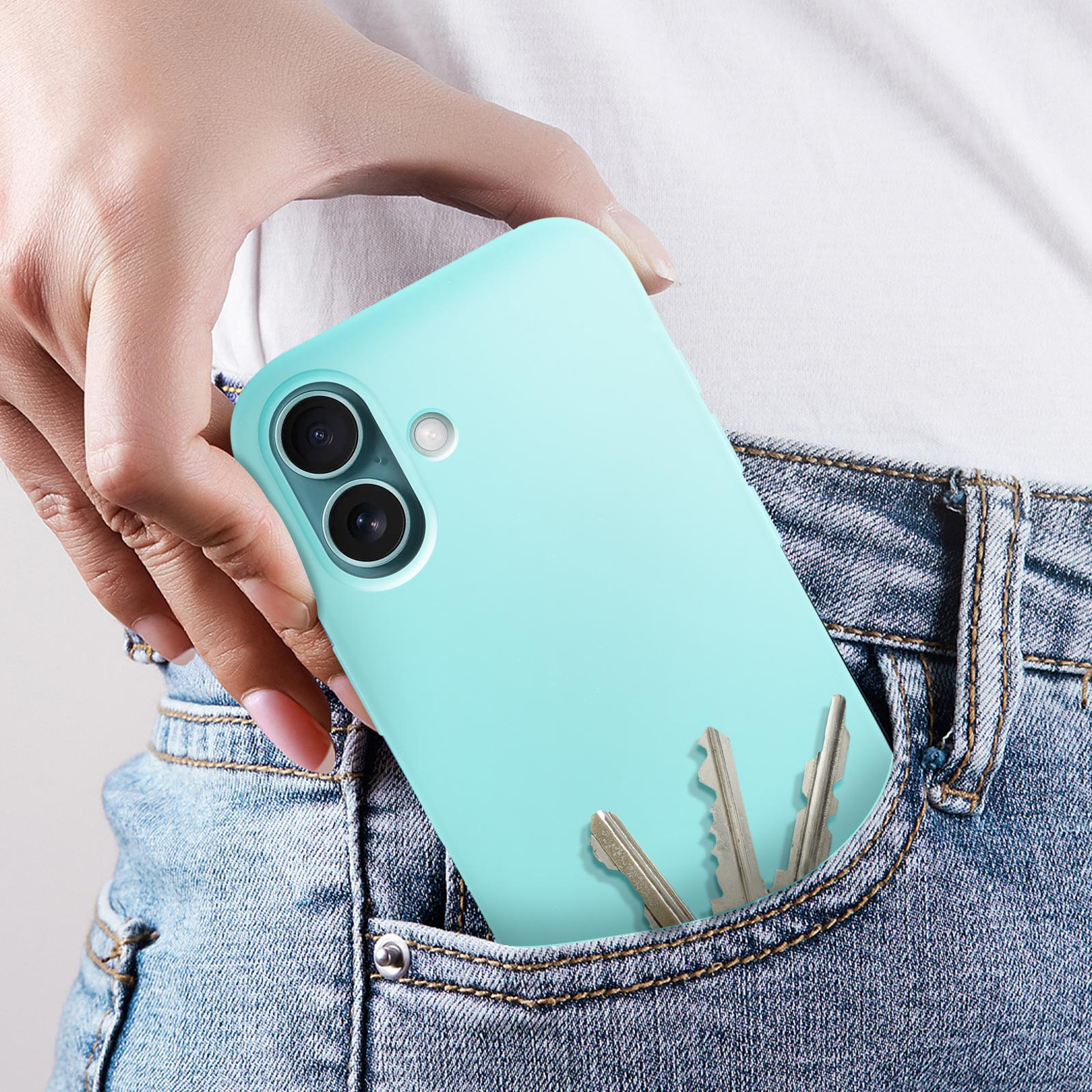 Une main tenant un téléphone bleu clair dans une poche, avec quelques clés visibles.