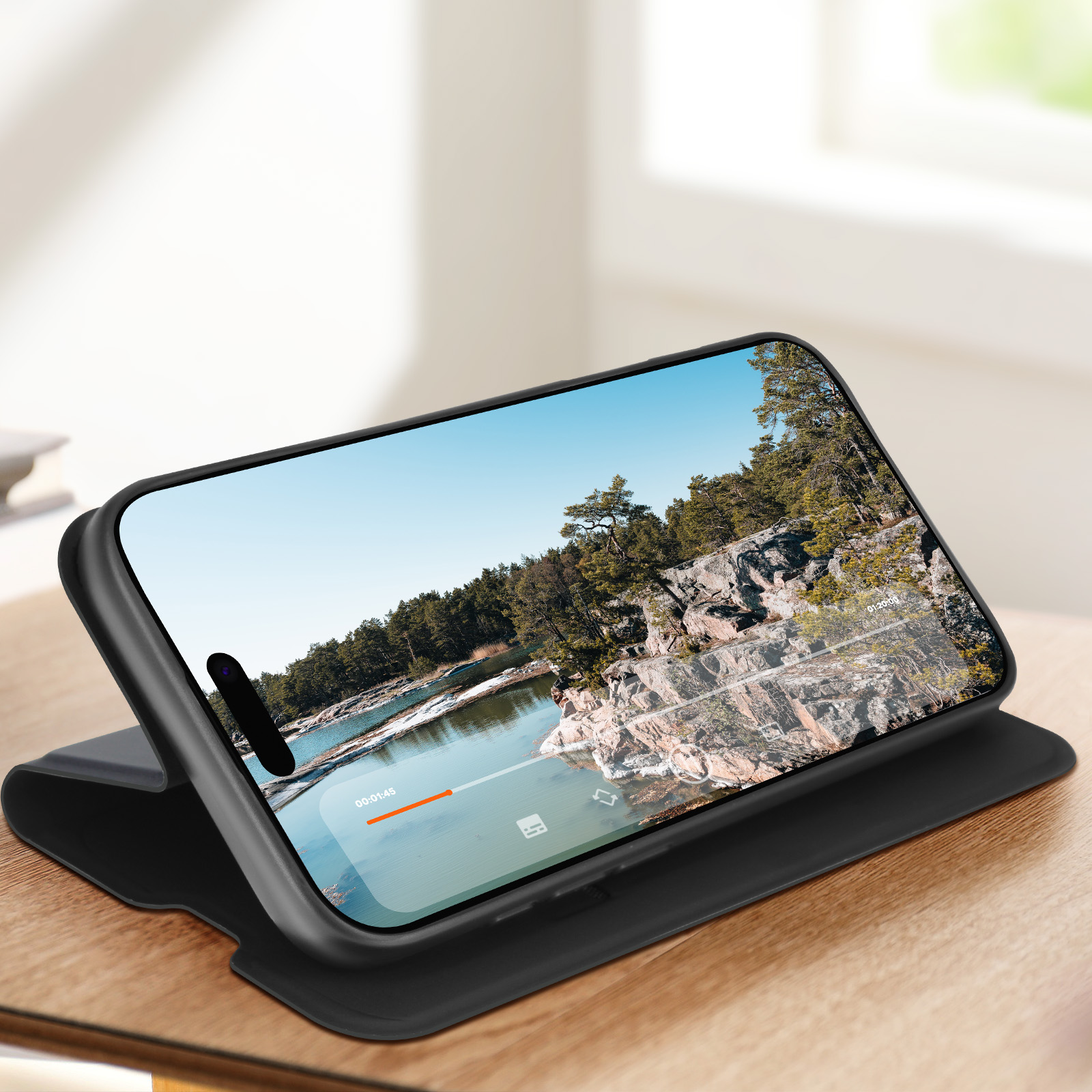 Telefono in una custodia su un supporto, che mostra un paesaggio con un lago e alberi.