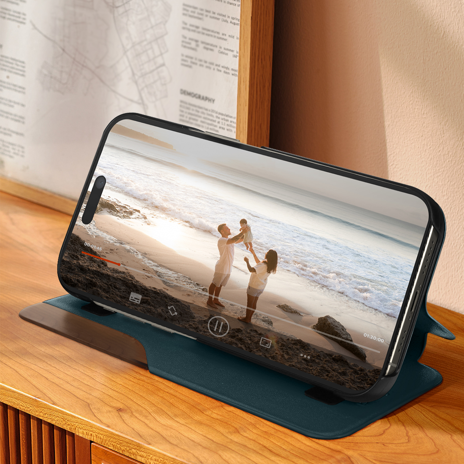 Telefon zeigt Video einer Familie am Strand. In blauer Geldbörsenhülle auf Holztisch.