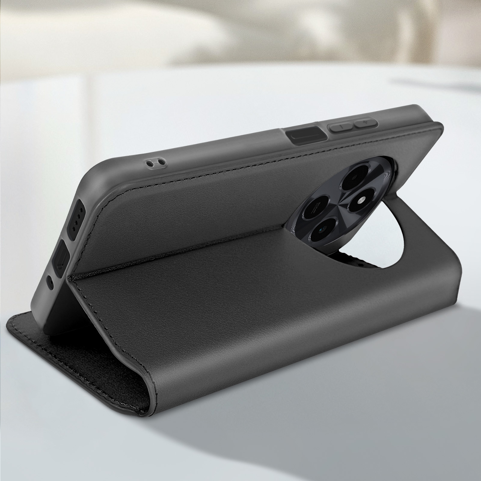 Una cover nera per telefono aperta per rivelare il telefono, su una superficie bianca. Mostra il modulo fotocamera.