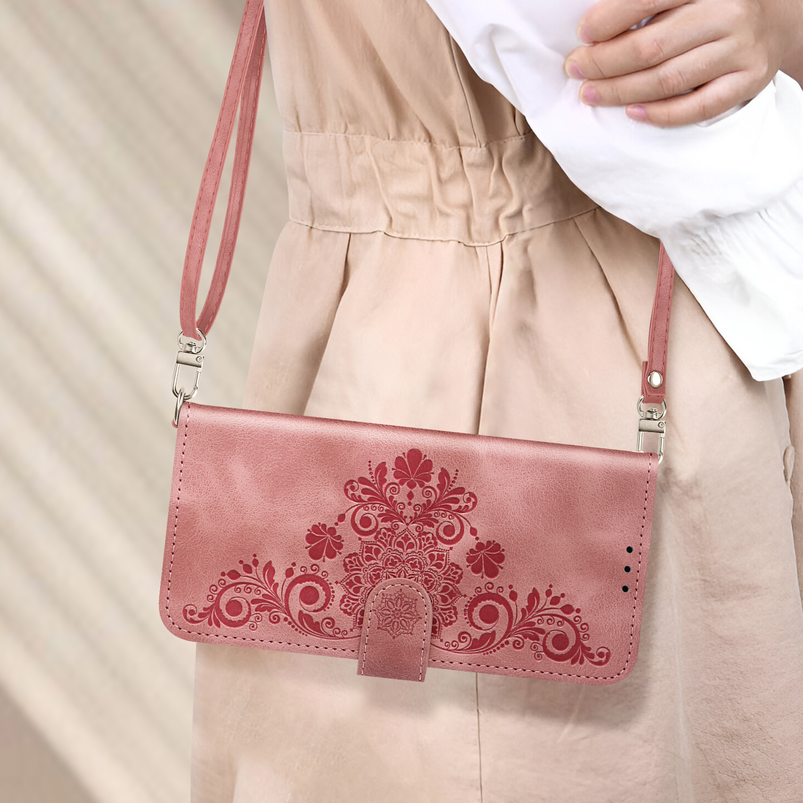 Donna con custodia rosa con cinturino. Design floreale dettagliato sulla custodia.