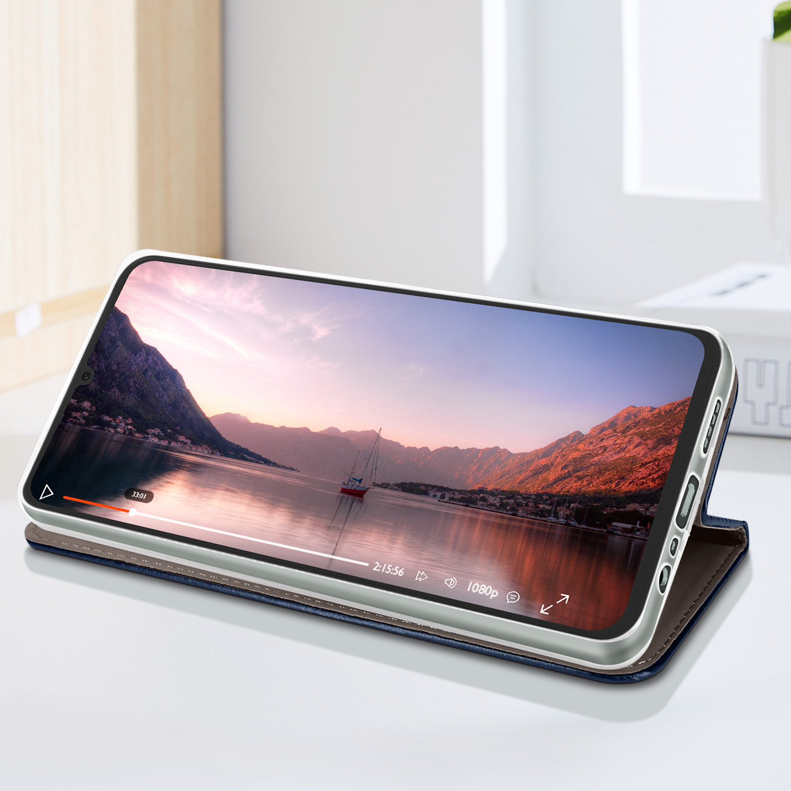 Telefono che mostra un video su un supporto. La cover è blu, con interno marrone.