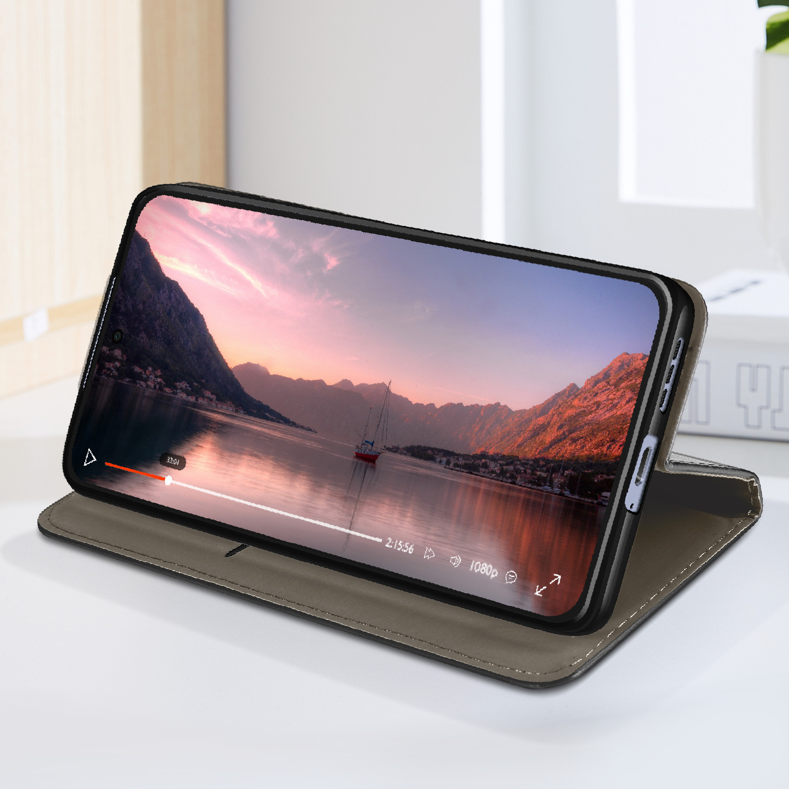 Telefon spielt Video auf Tisch, in brauner Handyhülle.