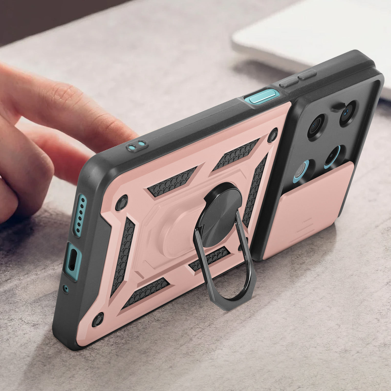 Custodia per telefono rosa e nera con supporto ad anello, posizionata su una scrivania.