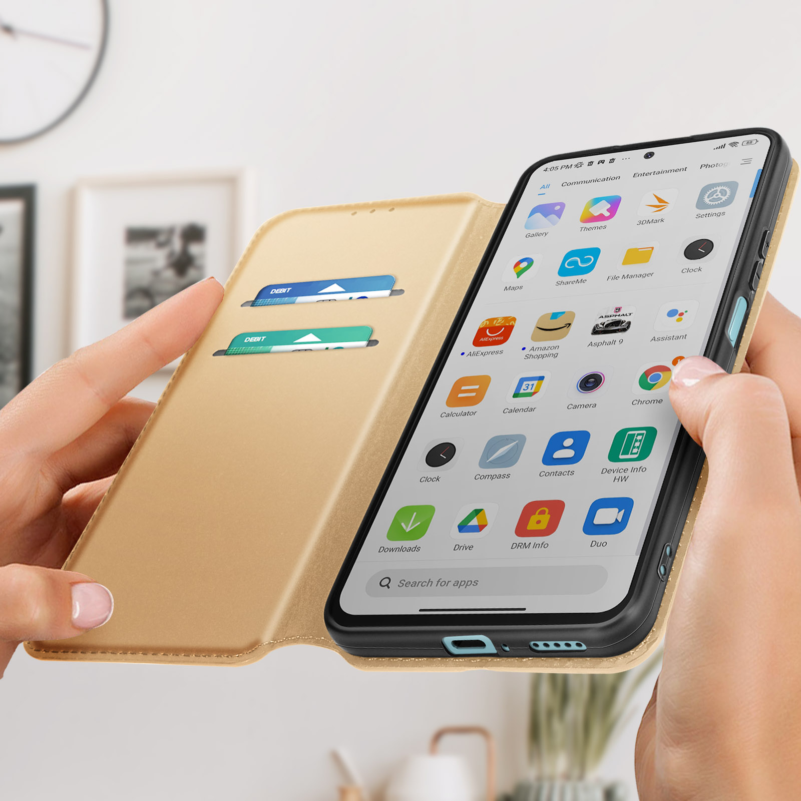 Una custodia per telefono dorata aperta con carte all'interno, un telefono che mostra icone di app, è tenuto in mano.