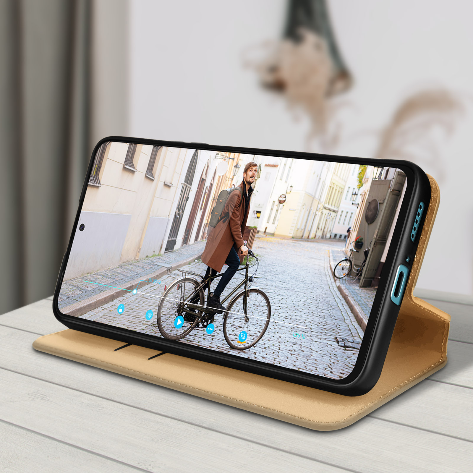Un telefono mostra una persona che va in bicicletta in una via della città. Il telefono è in una custodia.