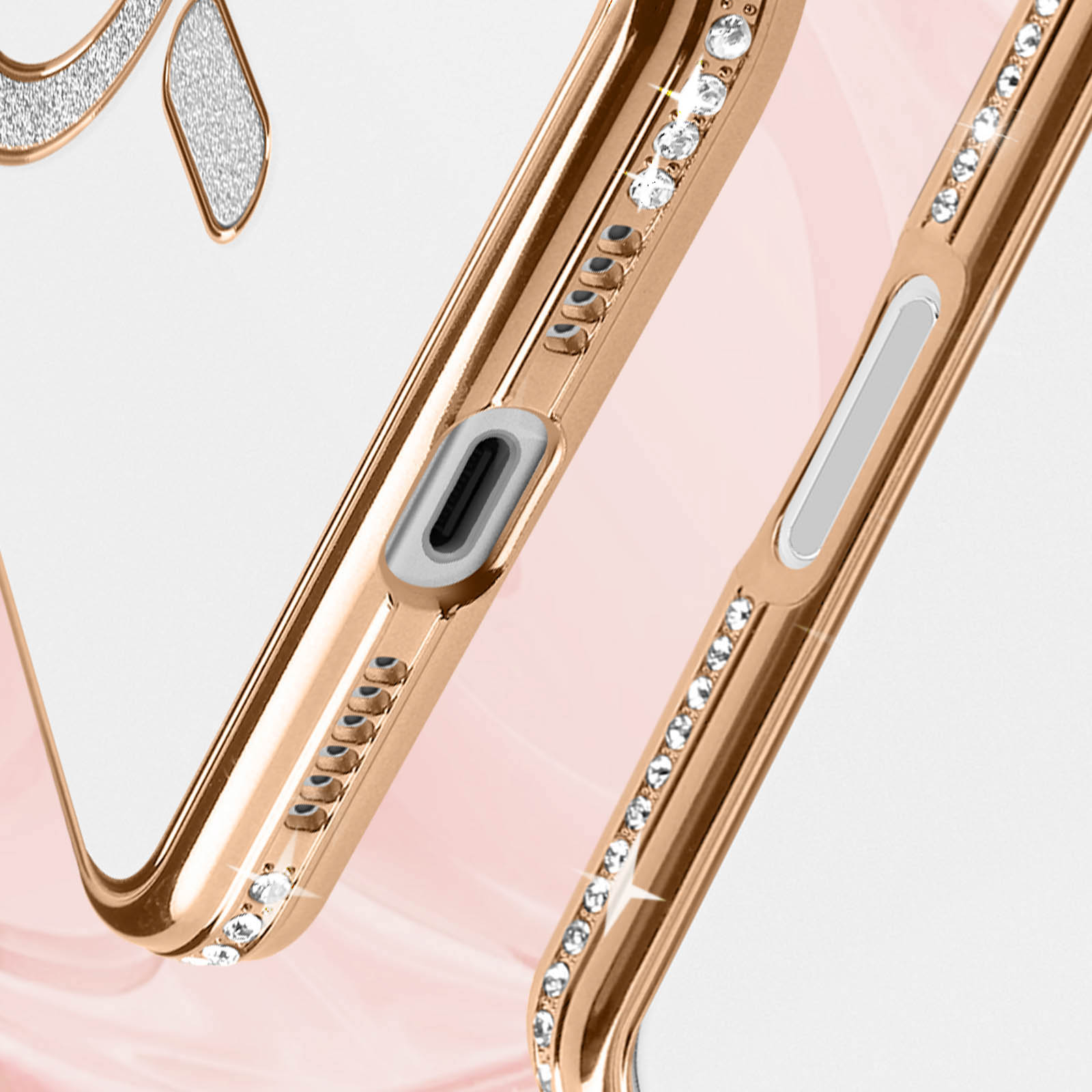 Close-up van een telefoonhoesje met een gouden frame met strass, met een roze achtergrond.